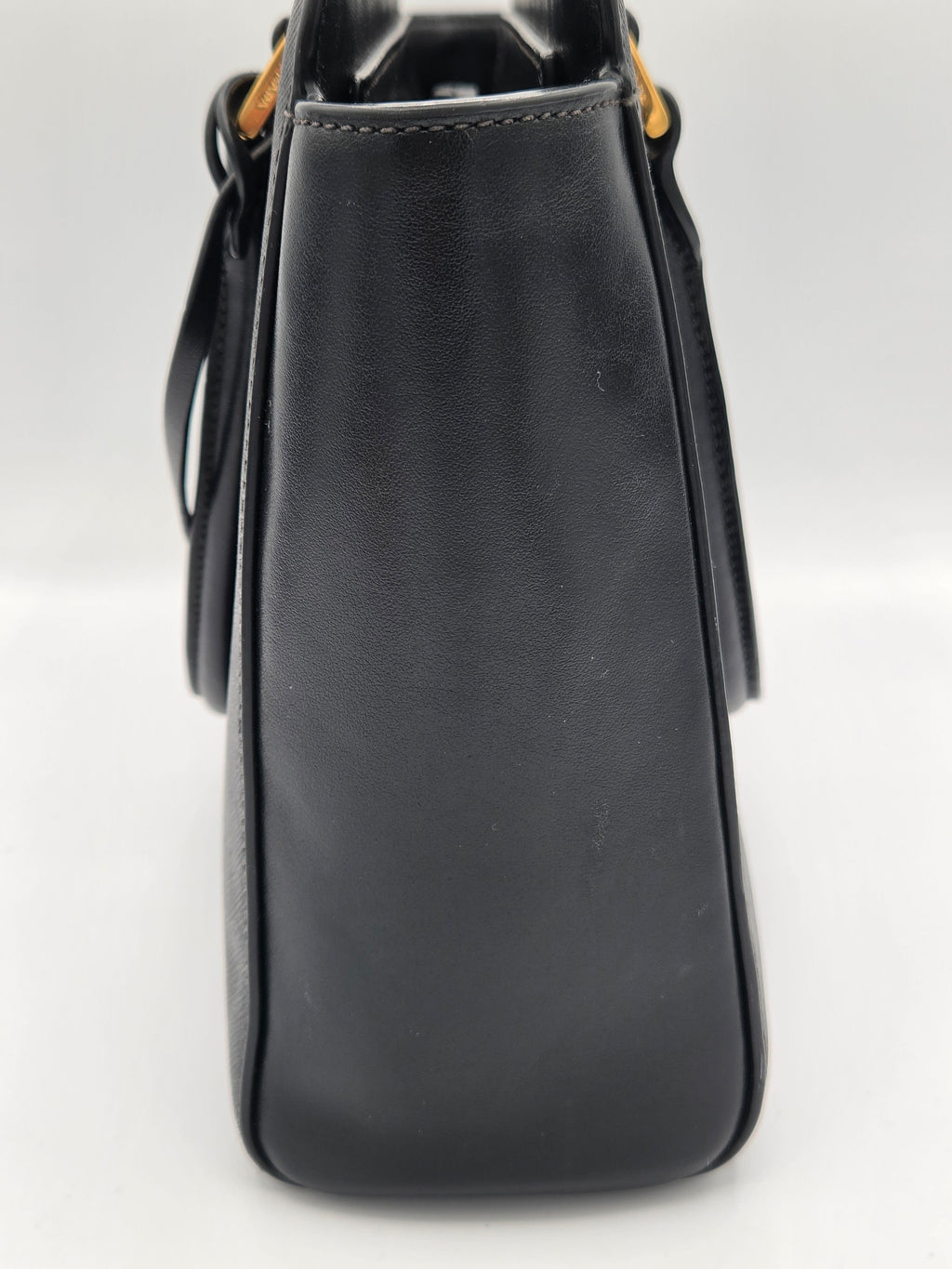 Black leather handbag on a light gray background