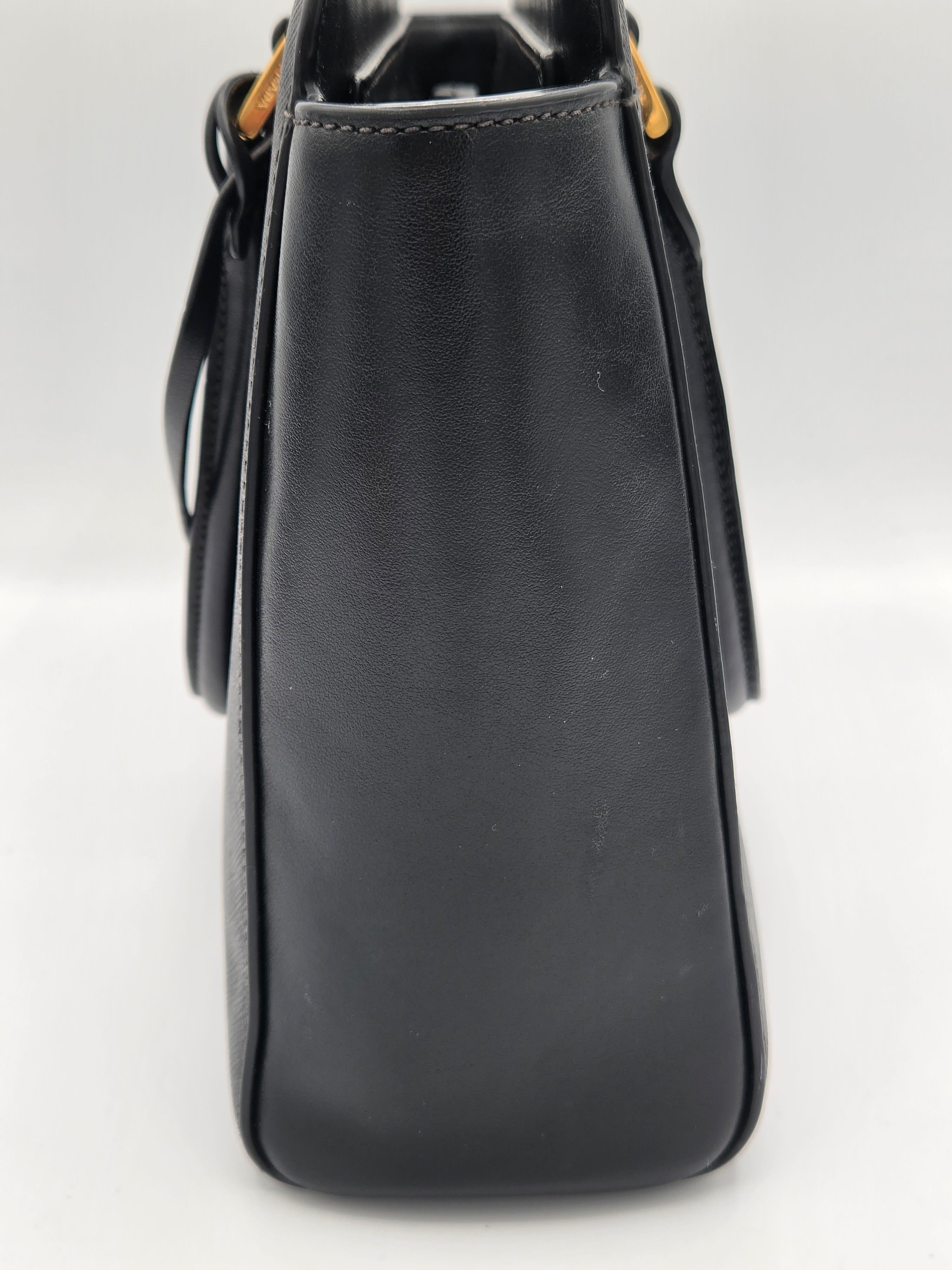 Black leather handbag on a light gray background