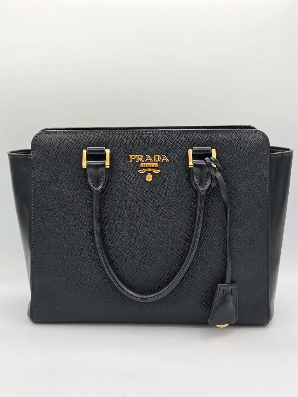 Black Prada handbag on a light gray background