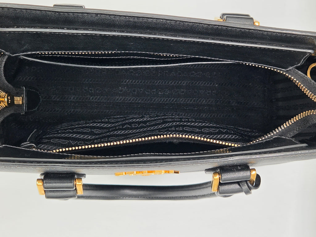Black suitcase with gold accents on a light gray background