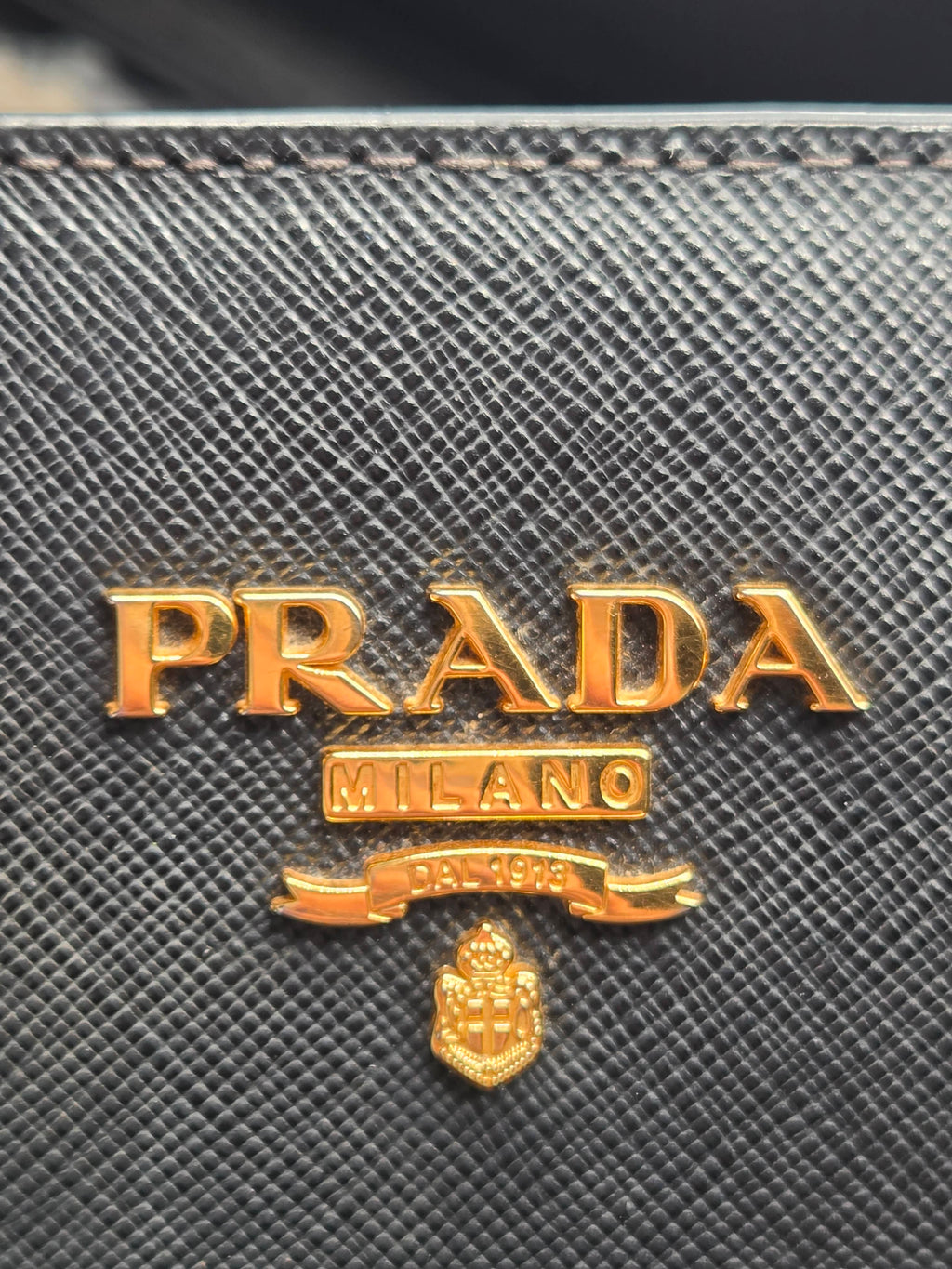 Close-up of Prada logo on a textured surface