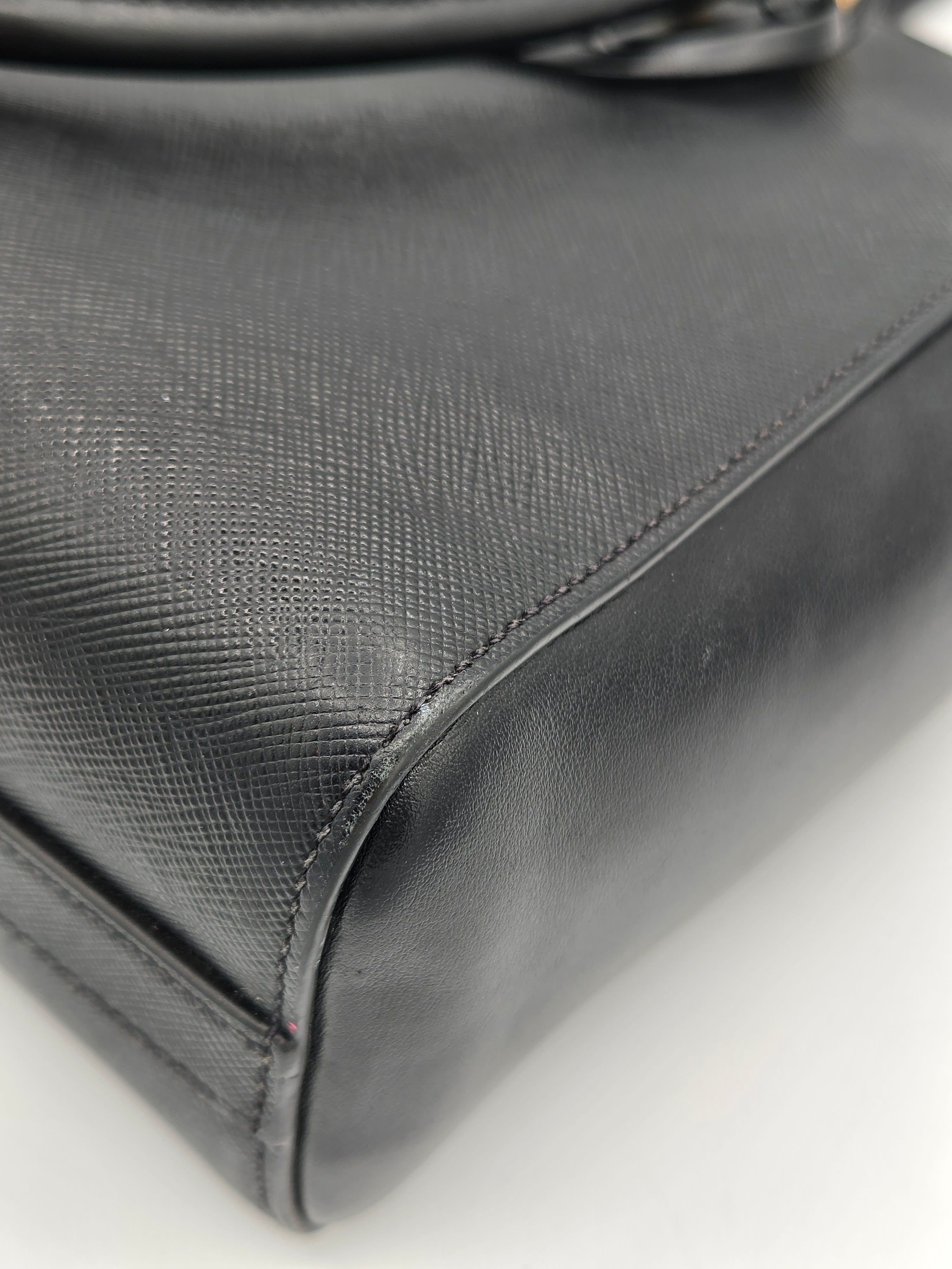 Close-up of a textured black leather bag corner on a light gray background