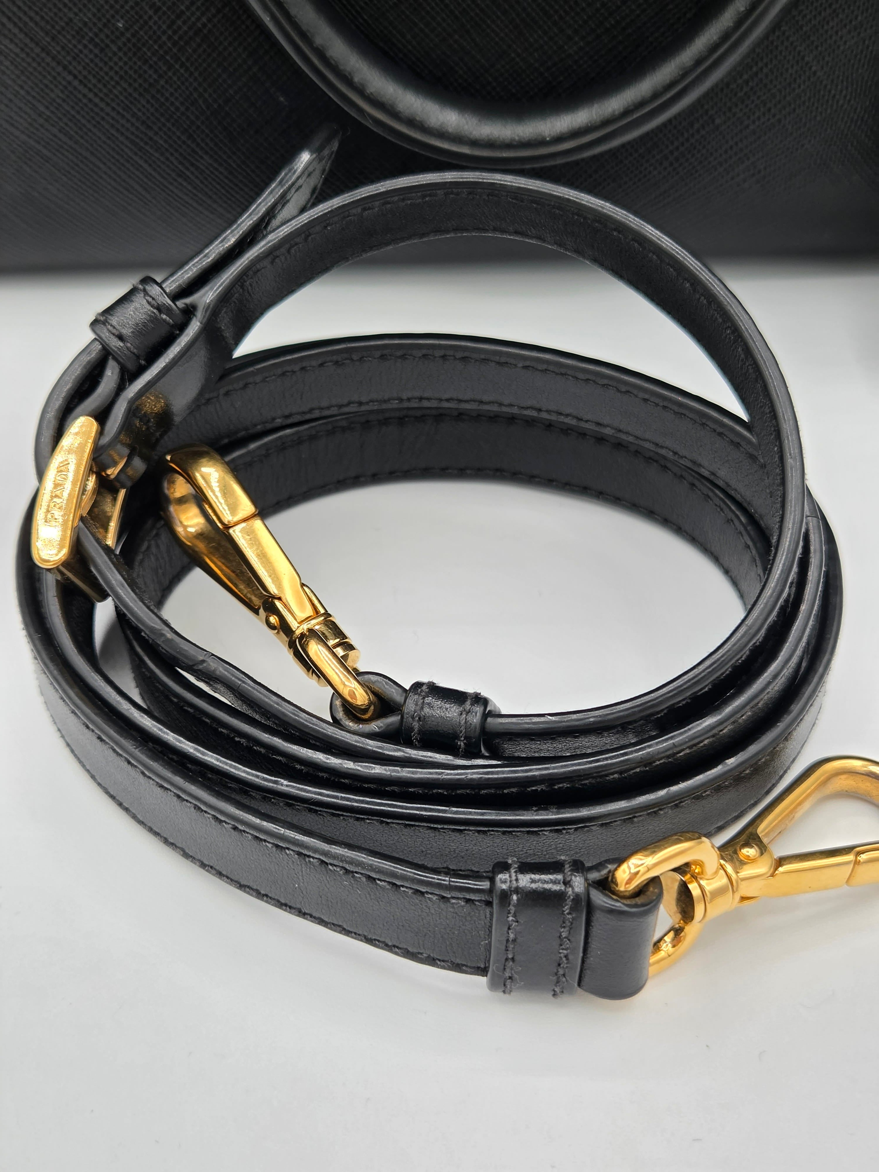 Black leather strap with gold hardware on a reflective surface
