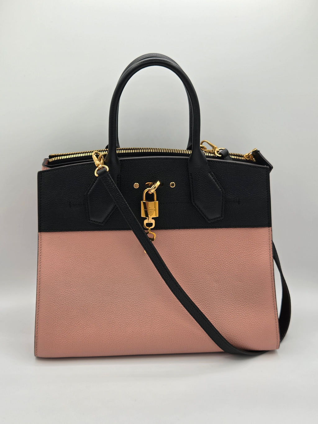 Two-toned handbag with black and pink sections on a light gray background