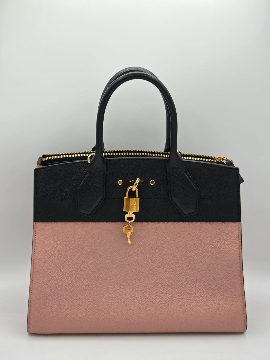 Two-toned handbag with black and pink sections on a light gray background