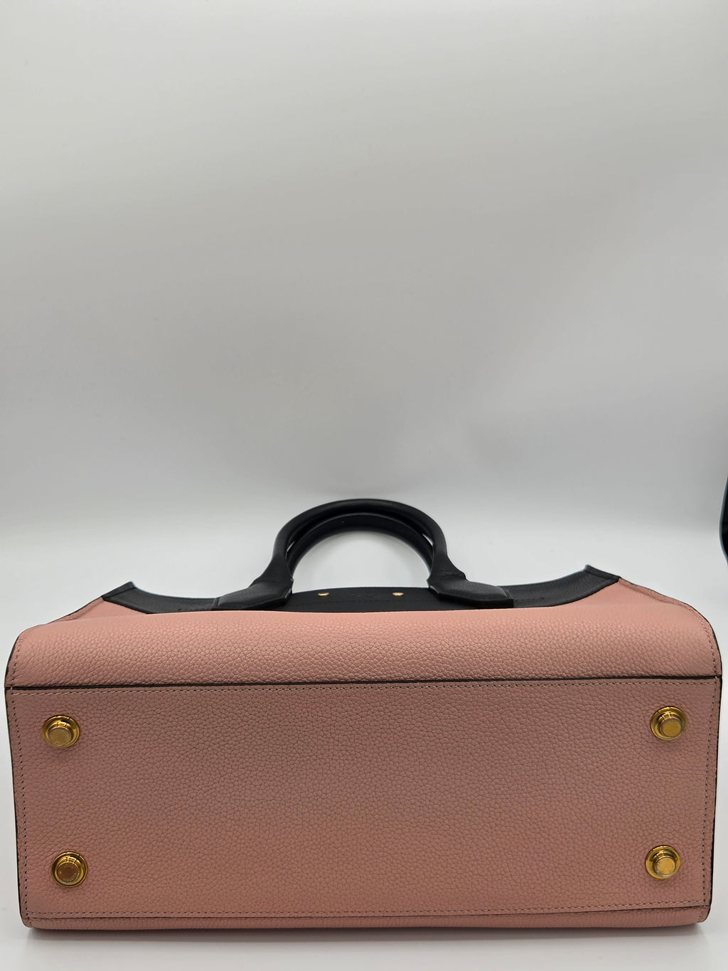 Pink leather briefcase with gold studs on a white background