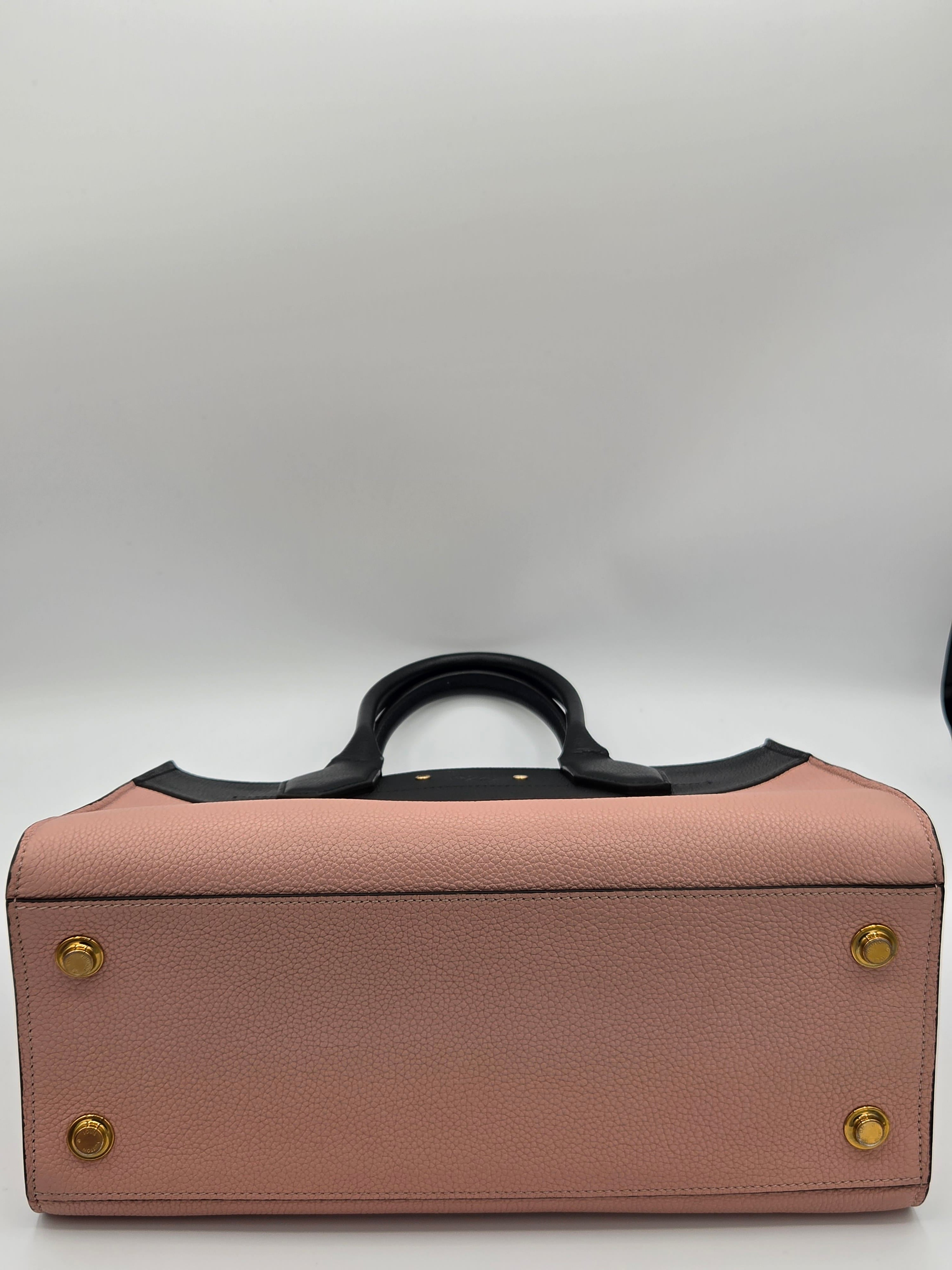 Pink leather briefcase with gold studs on a white background