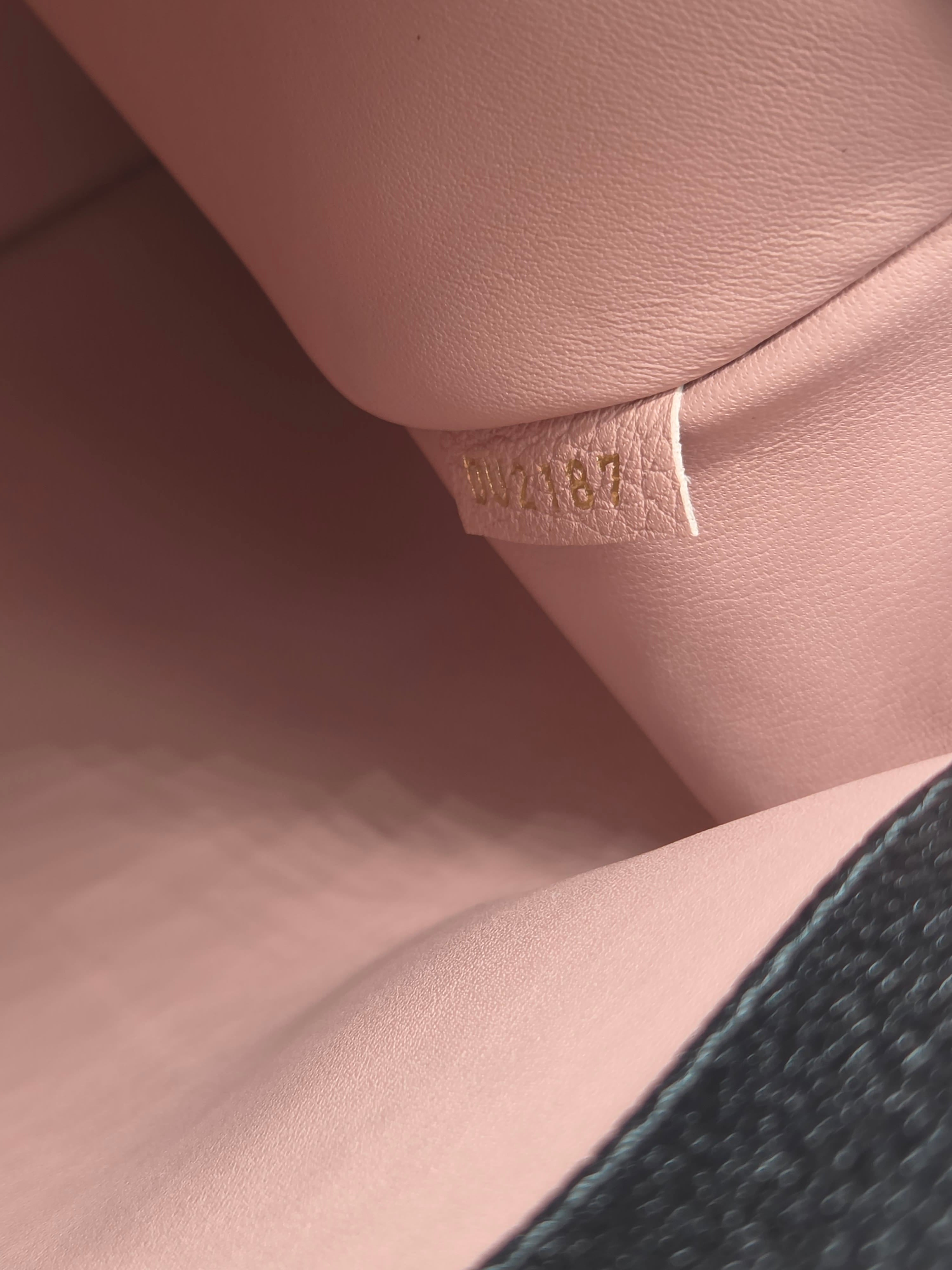 Close-up of a pink leather surface with a visible brand label.