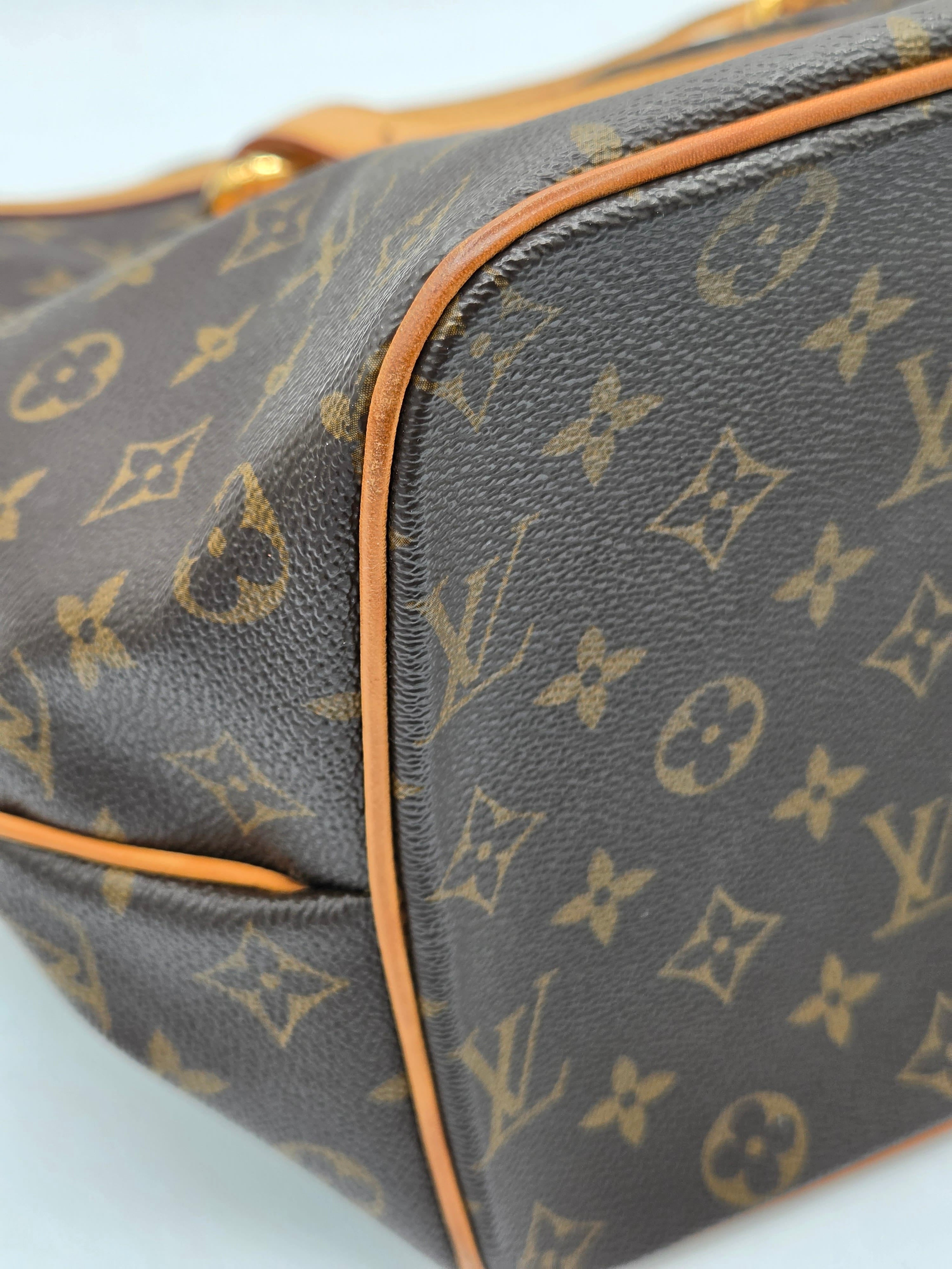 Close-up of a Louis Vuitton monogram bag with brown leather trim.