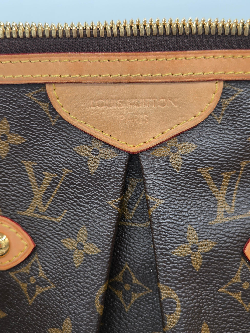 Close-up of a Louis Vuitton handbag with monogram pattern and visible brand logo.