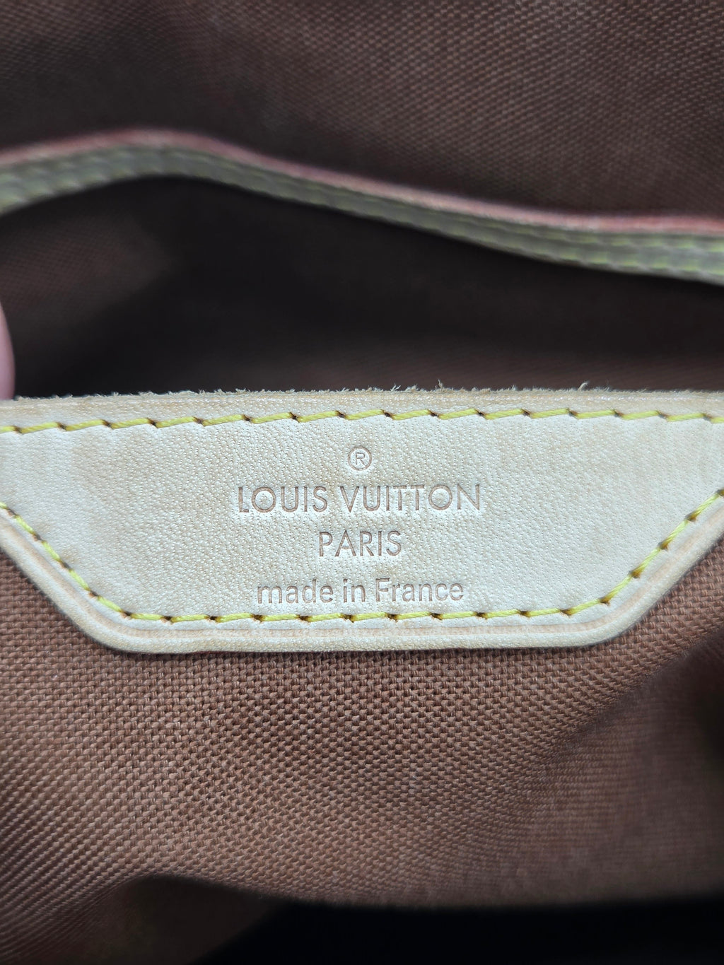 Louis Vuitton logo on a brown fabric background