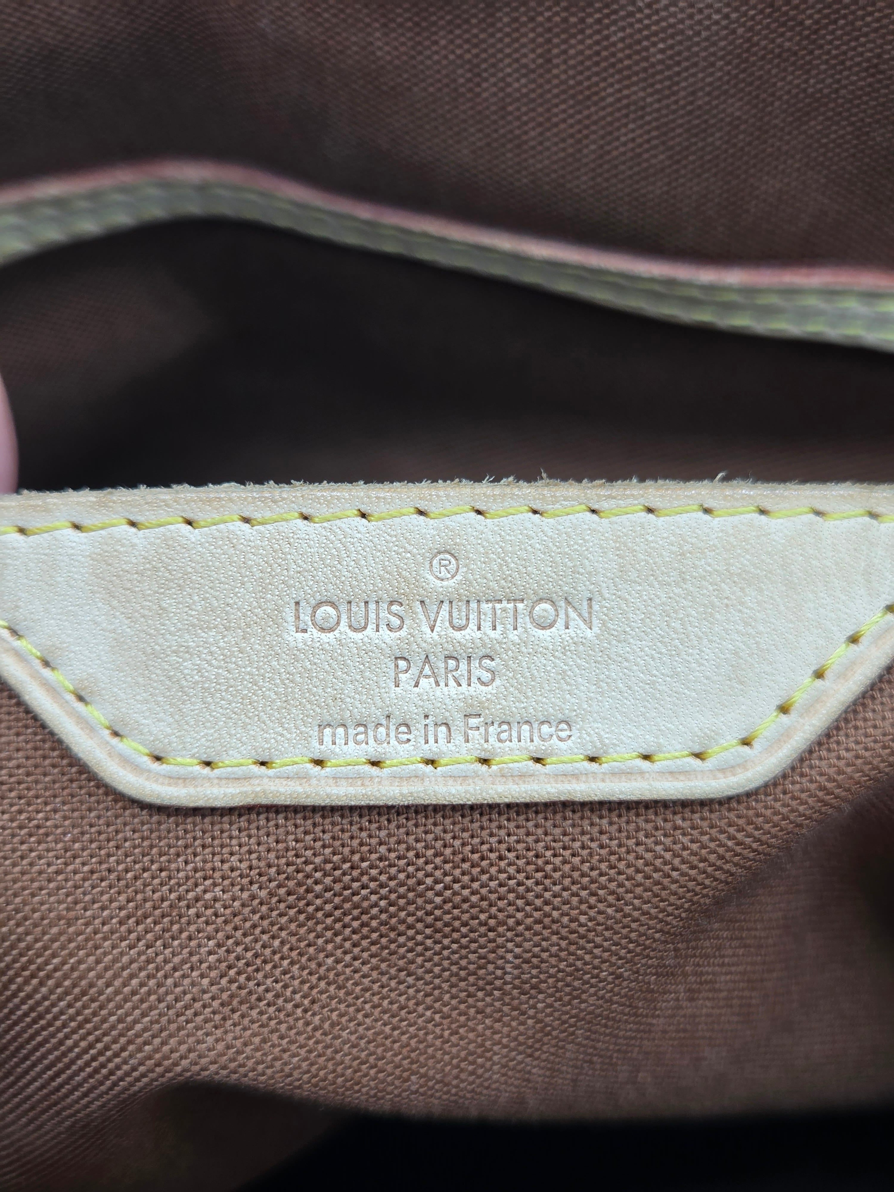 Louis Vuitton logo on a brown fabric background