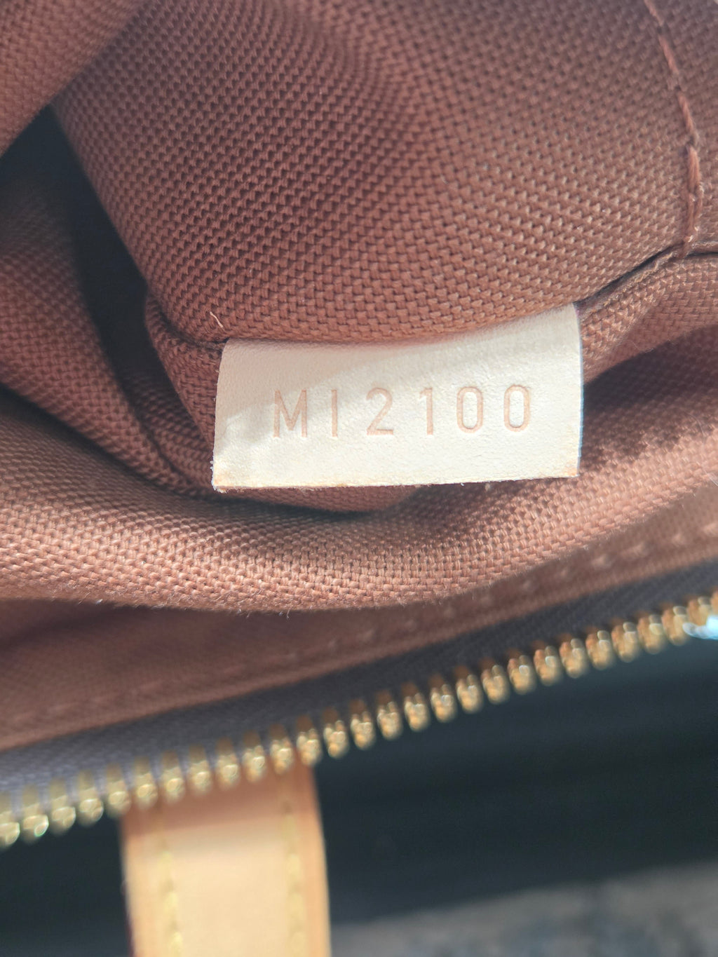 Close-up of a brown fabric with a visible label and zipper.