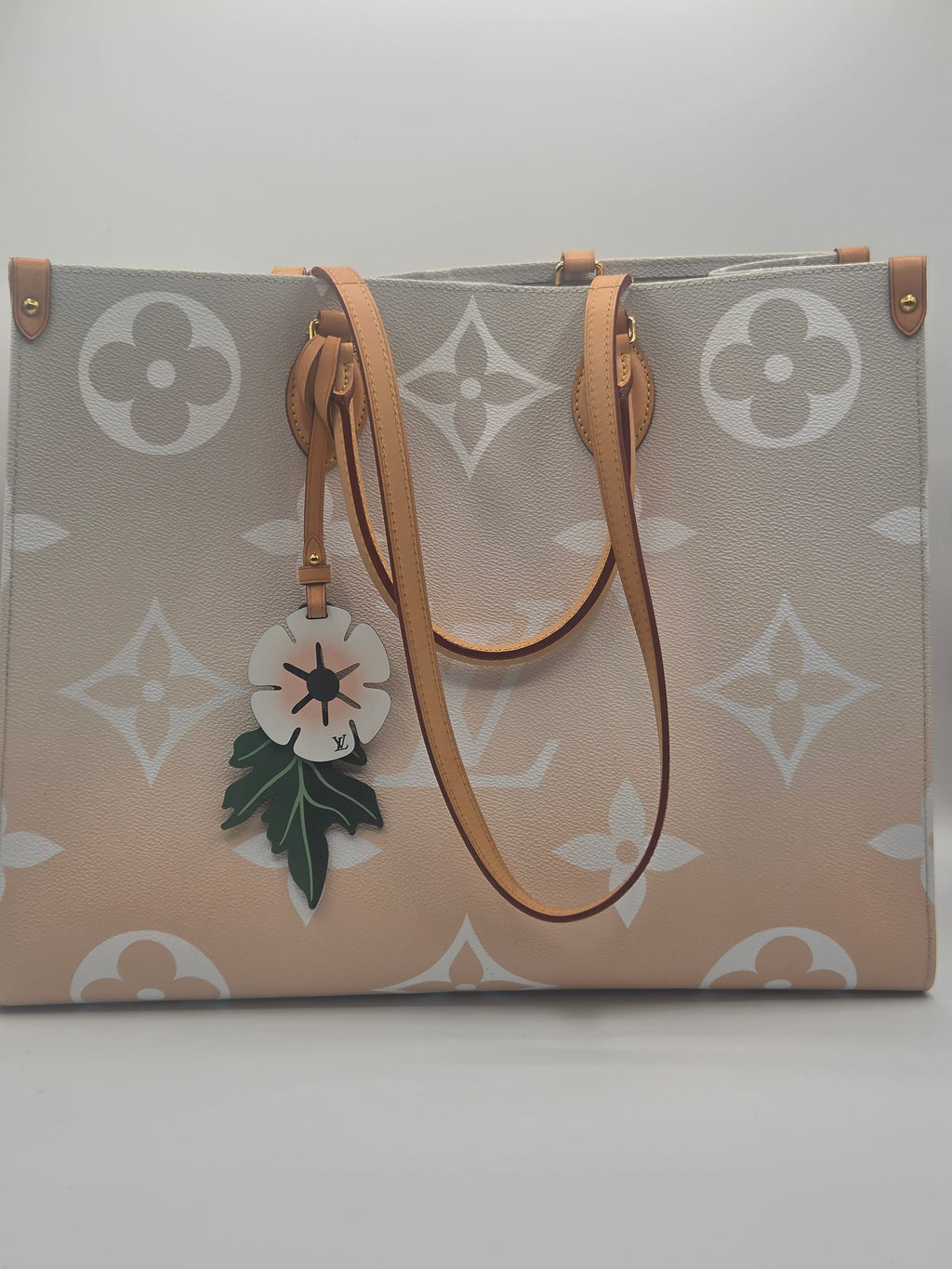 Designer handbag with floral charm on a light background