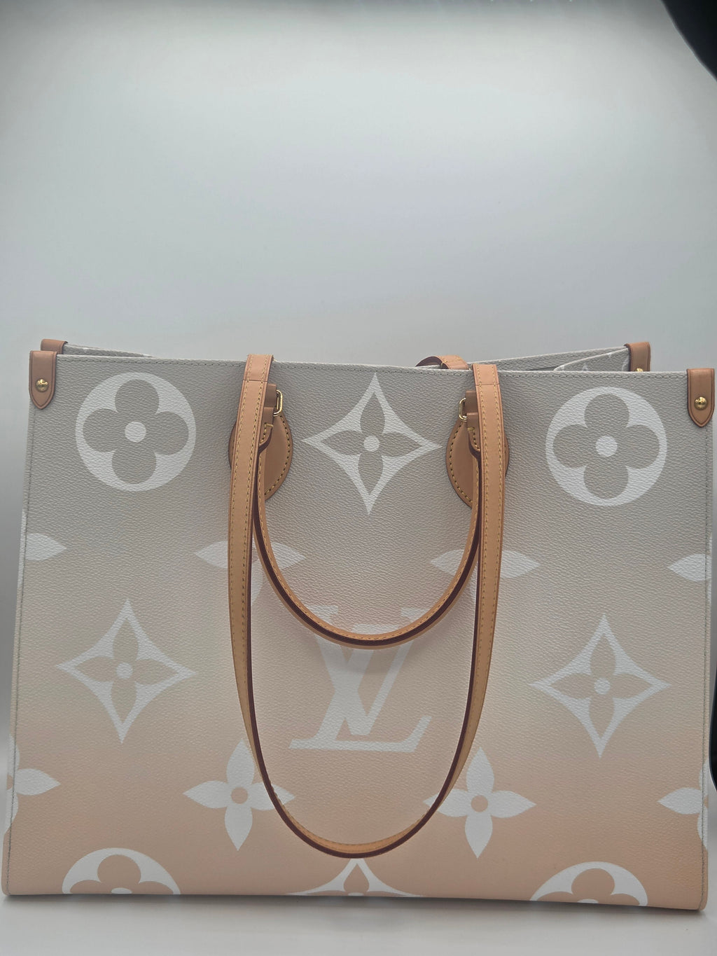 Designer handbag with monogram pattern on a light gray background