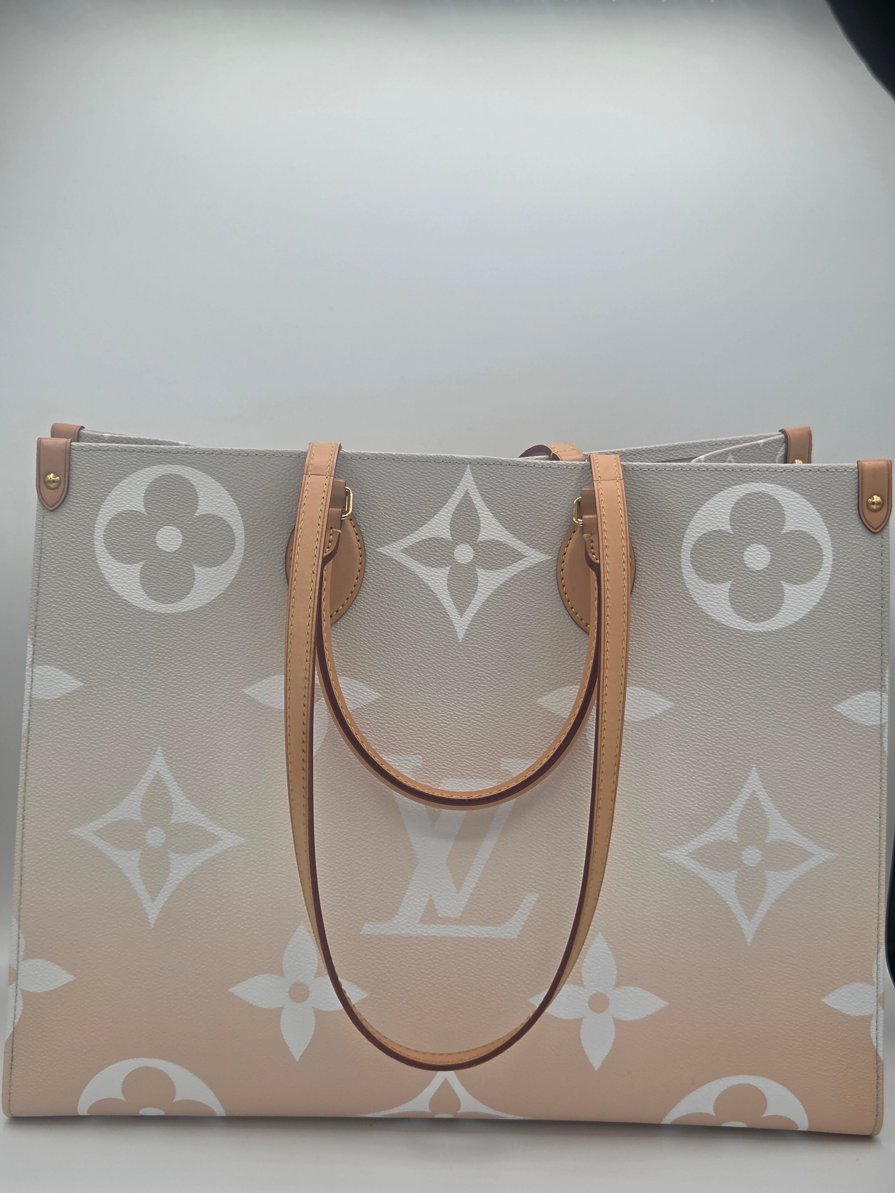 Designer handbag with monogram pattern on a light gray background