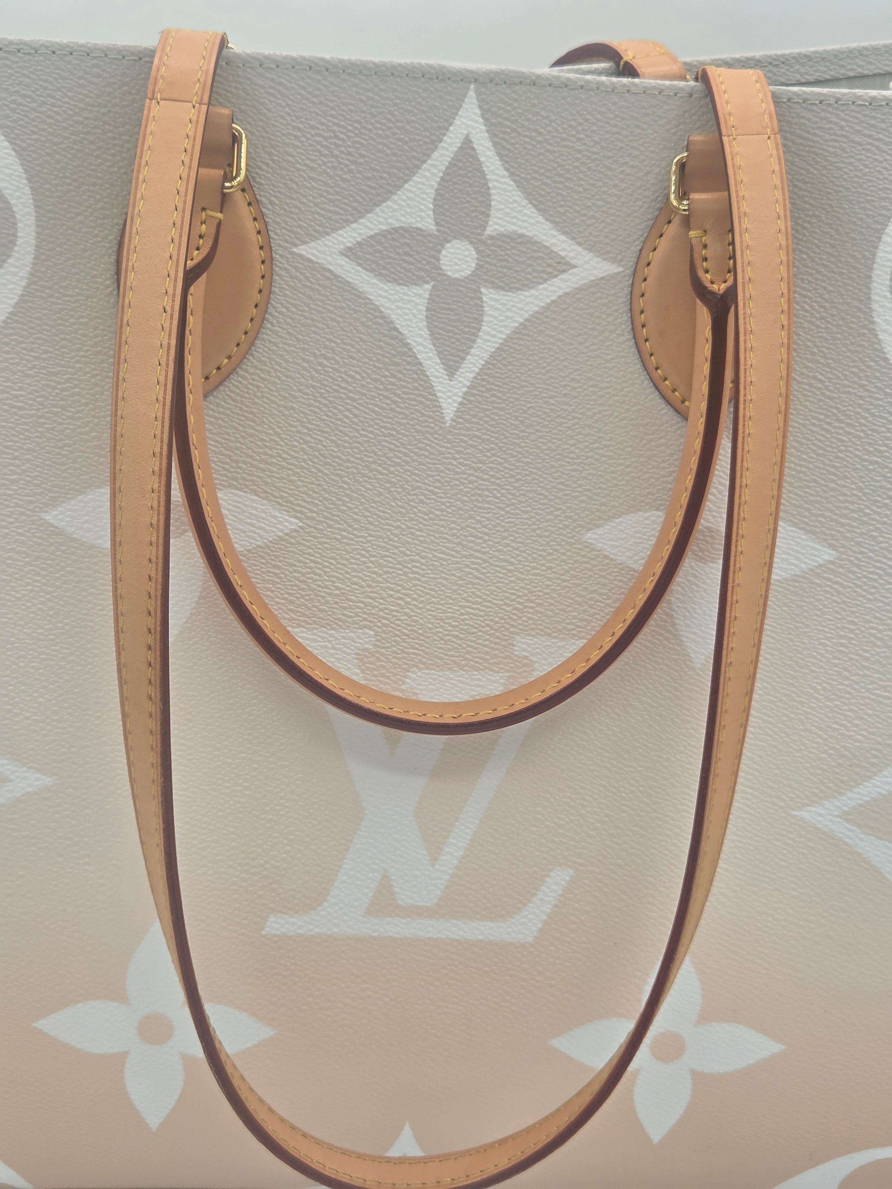 Designer handbag with monogram pattern and brown leather strap