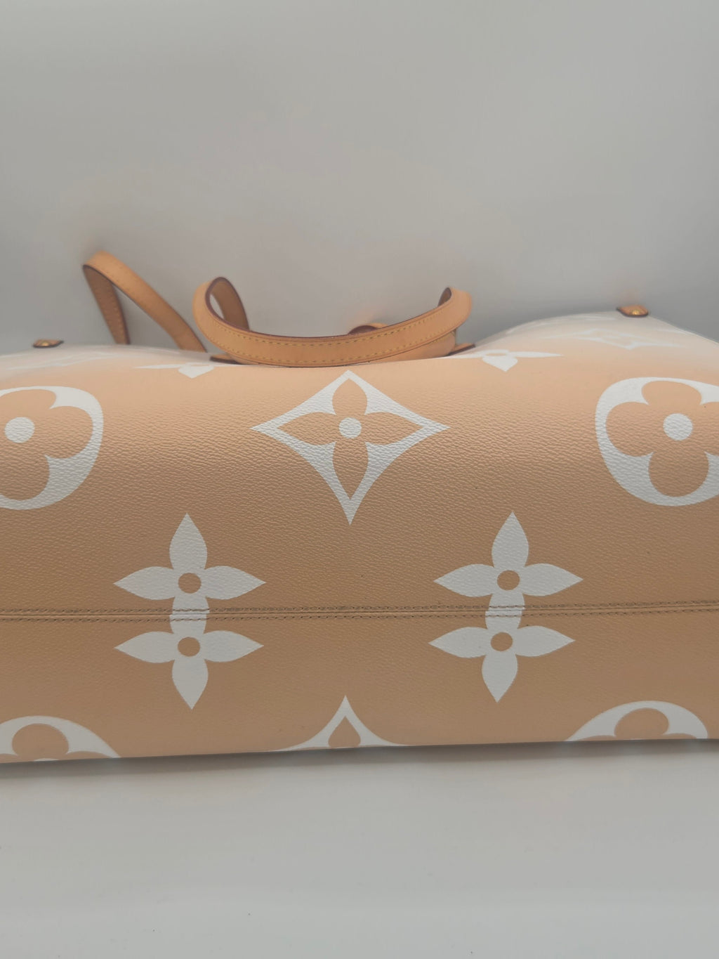 Beige ironing board with white floral pattern on a plain background