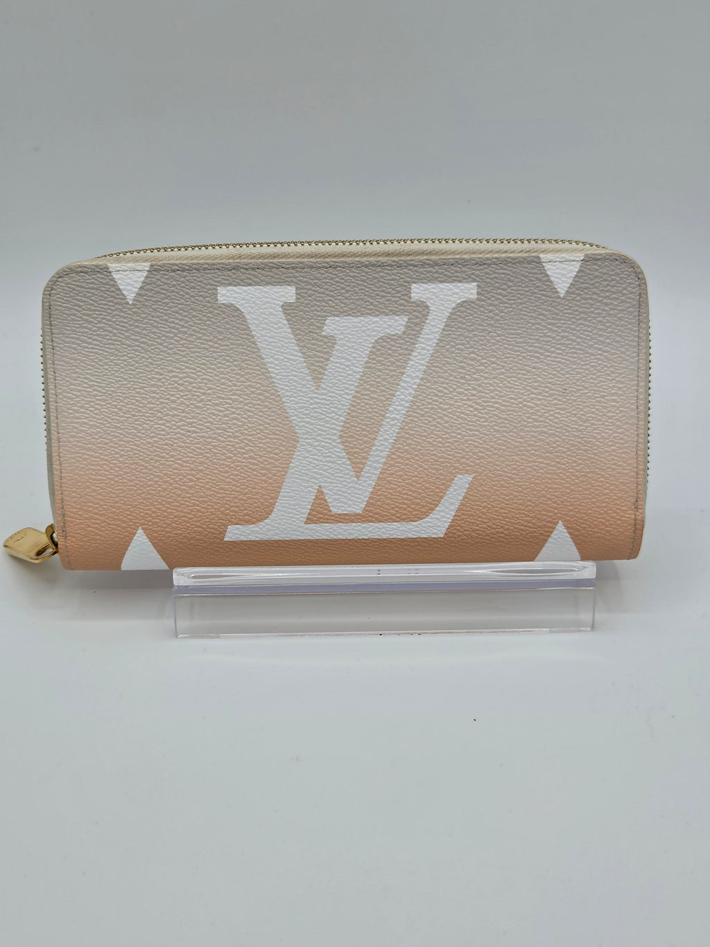 Beige wallet with a prominent logo on a light gray background