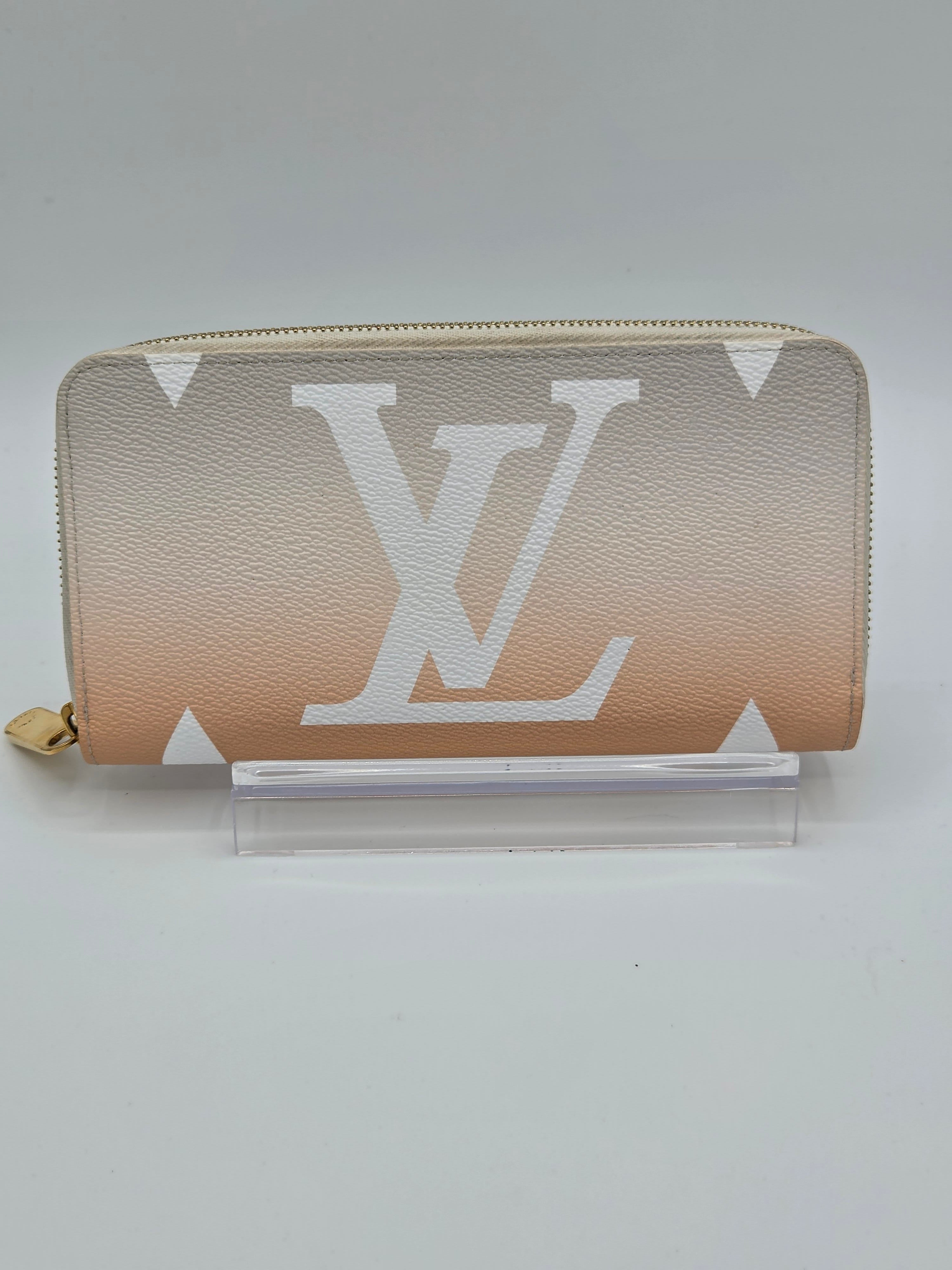 Beige wallet with a prominent logo on a light gray background