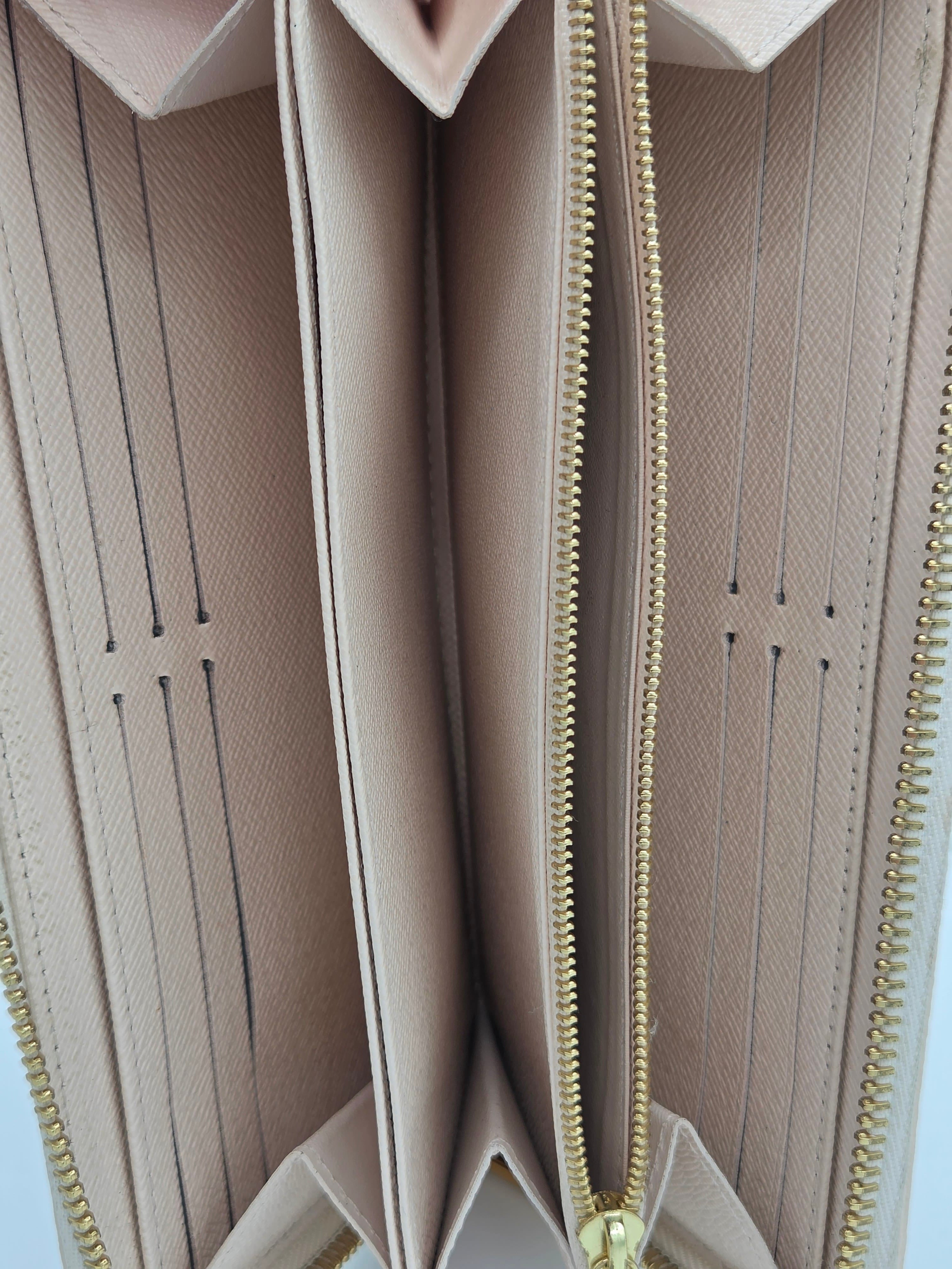 Close-up of a beige wallet with gold zipper