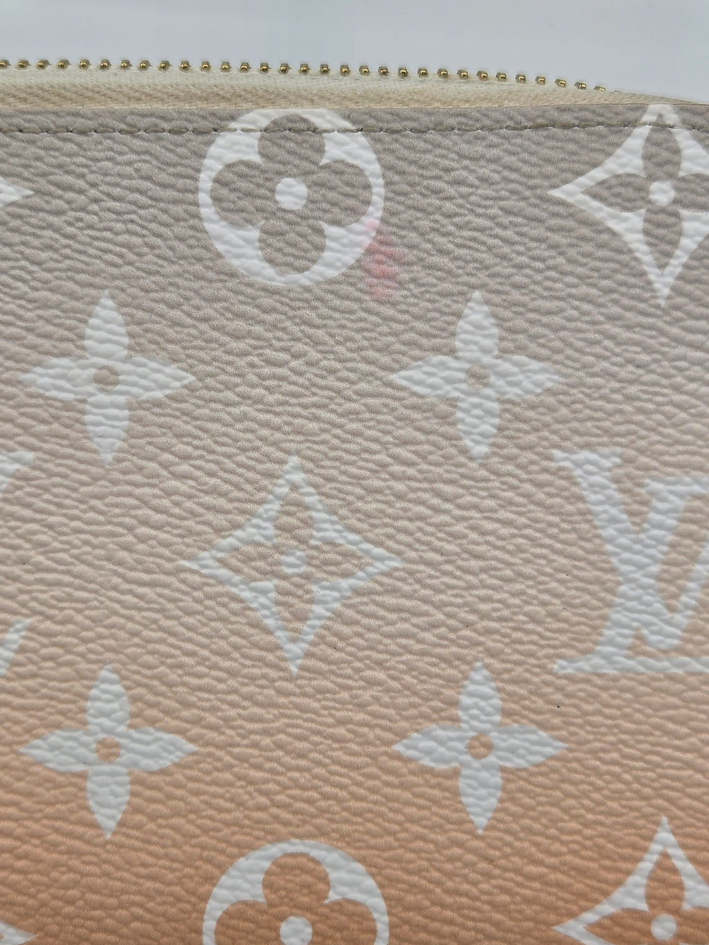 Close-up of a beige fabric with a white logo pattern