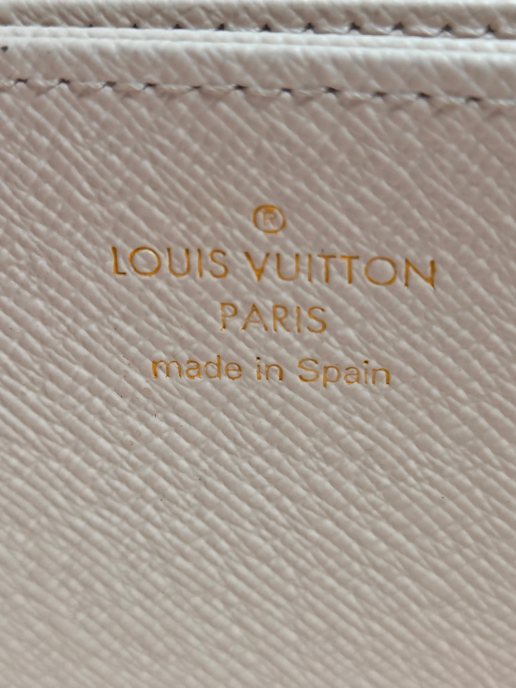 Louis Vuitton logo on a textured beige surface