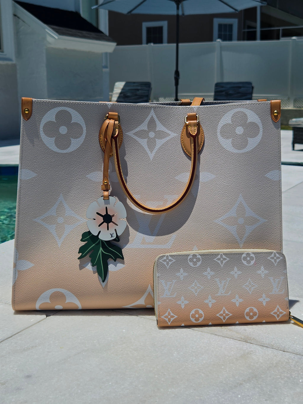 Designer handbag with floral detail on a reflective surface