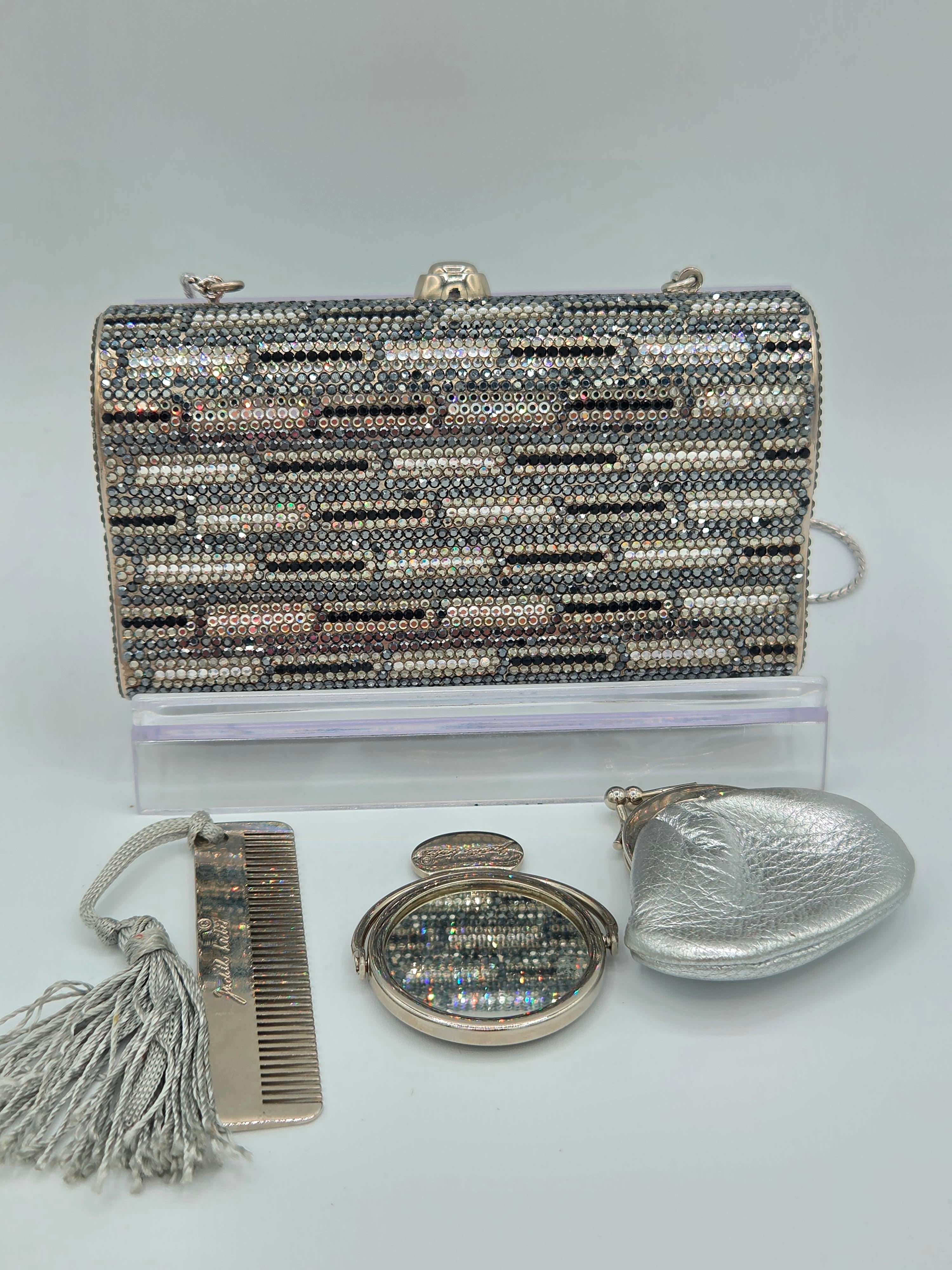 Silver beaded handbag with matching compact mirror and comb on a light gray background