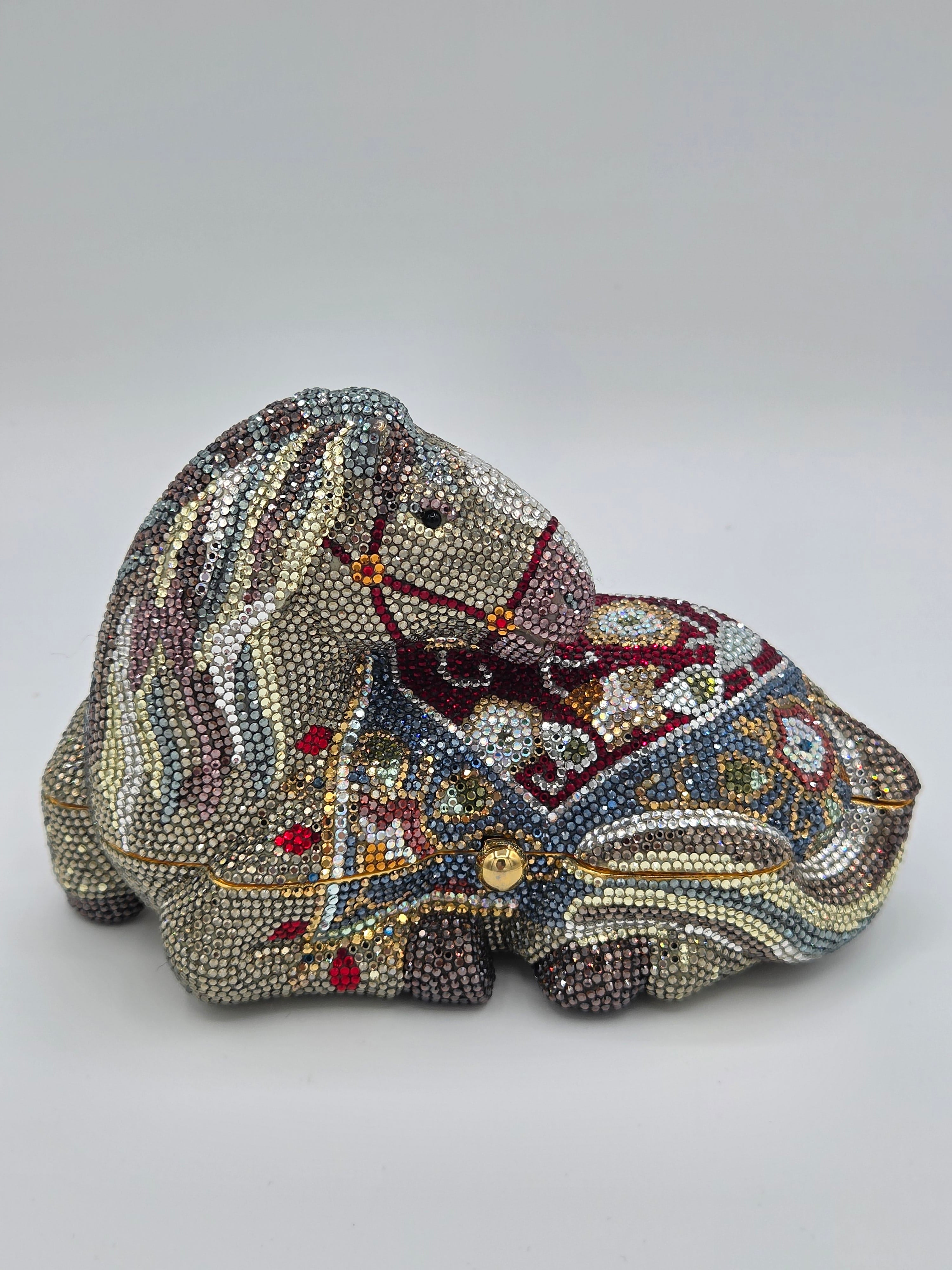 Decorative clutch bag with intricate beadwork on a light gray background