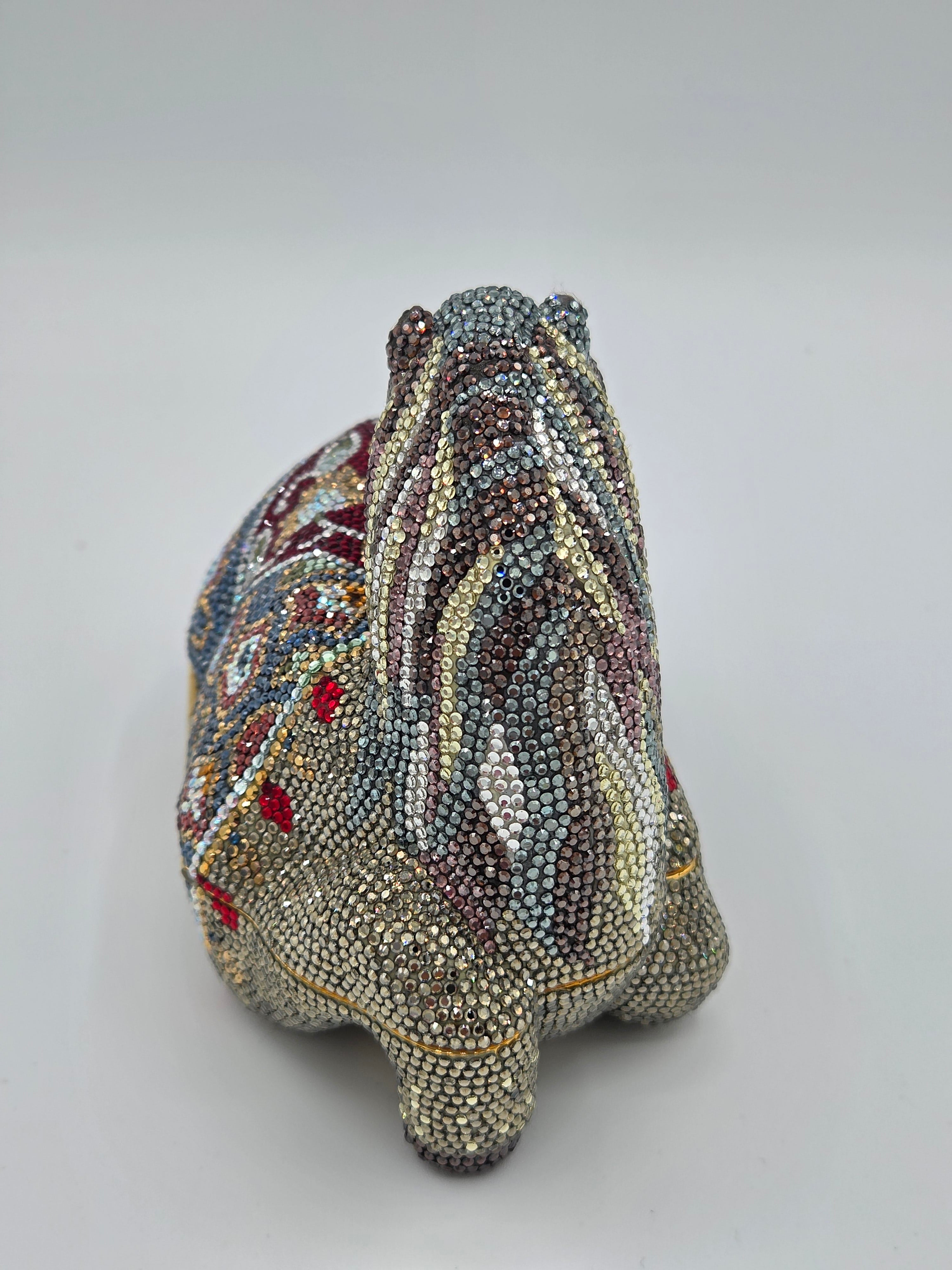 Decorative object resembling a fish made of beaded material on a plain background