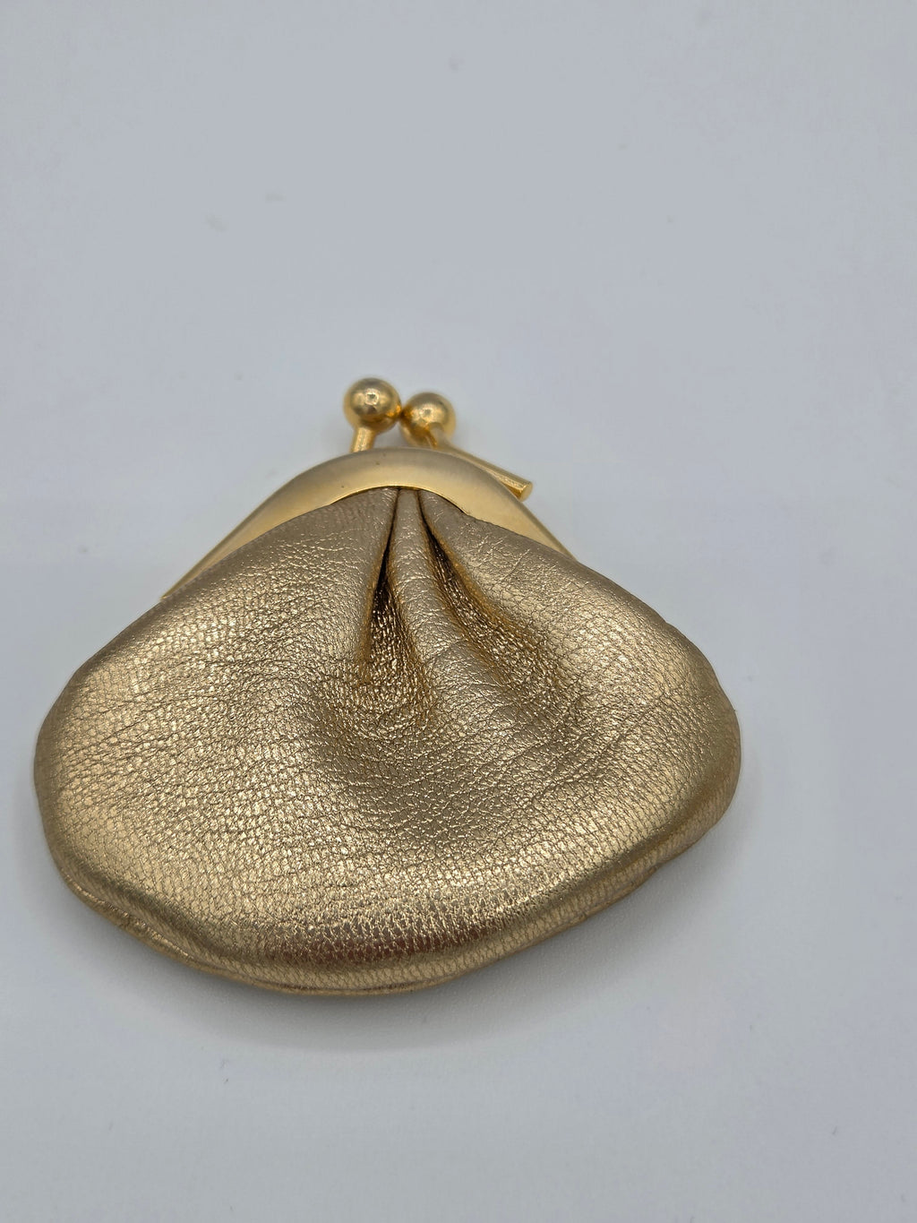 Gold leather pouch with a clasp on a gray background