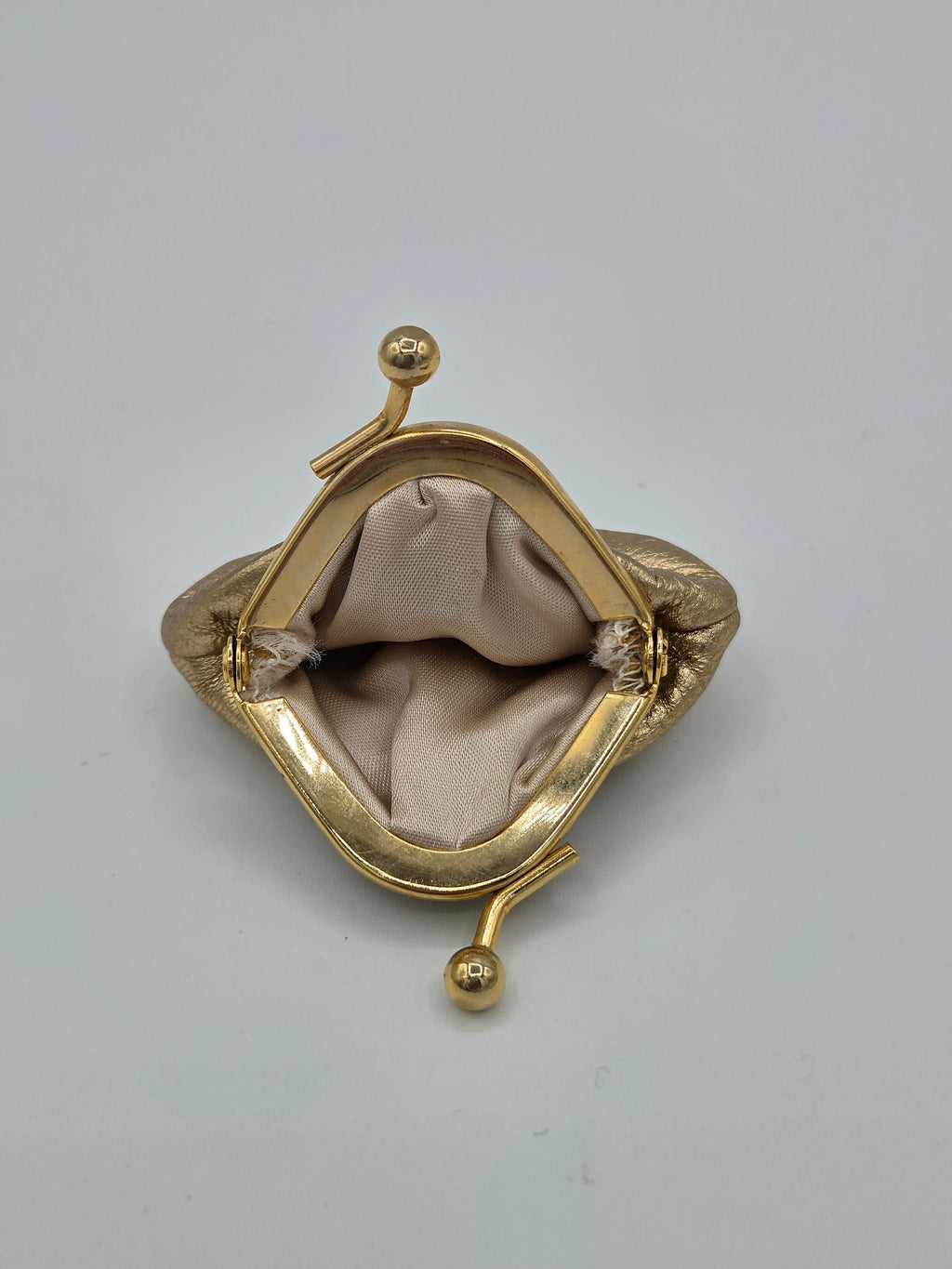 Gold clutch purse on a light gray background