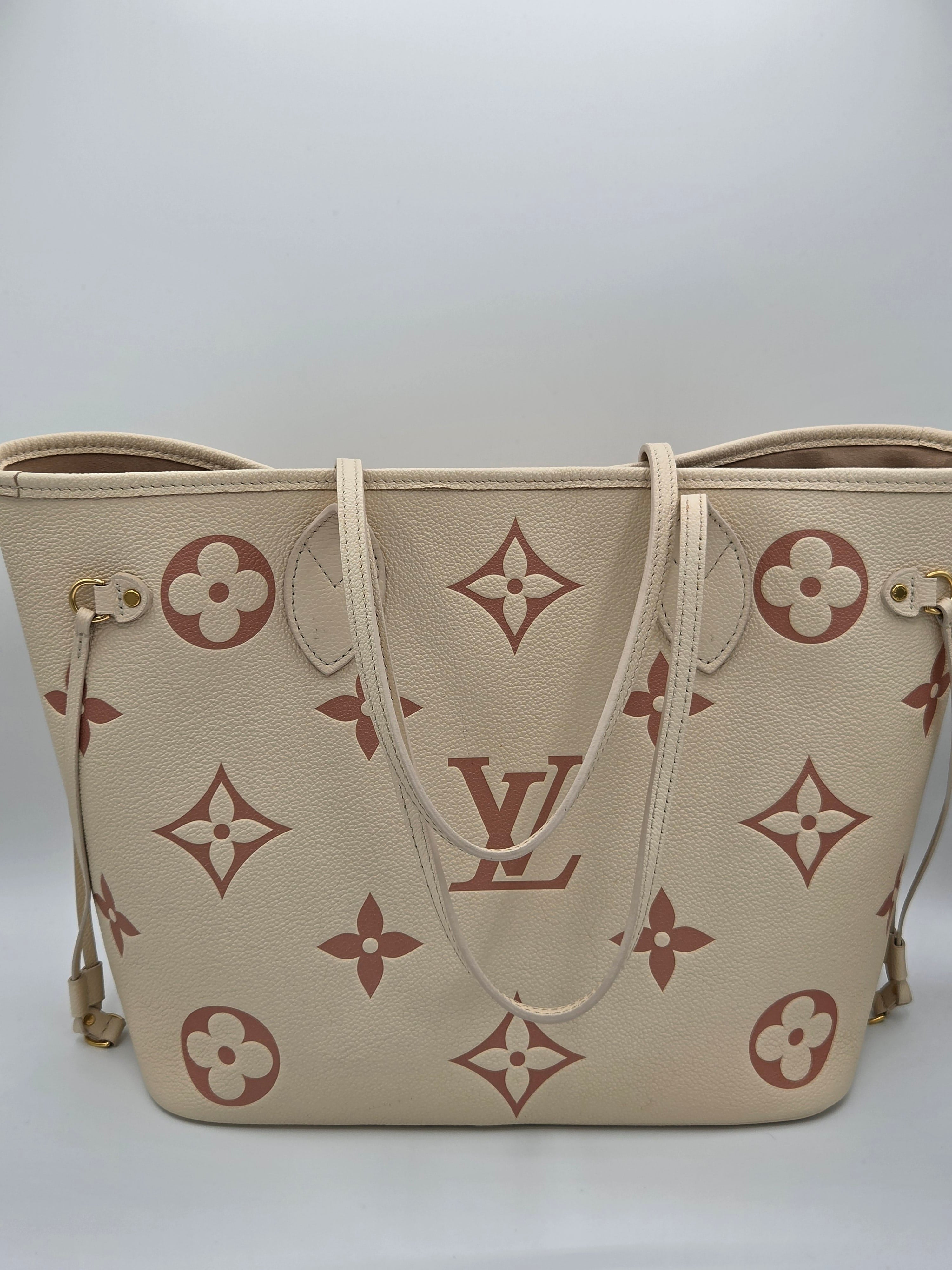 Beige handbag with brown monogram pattern on a white background
