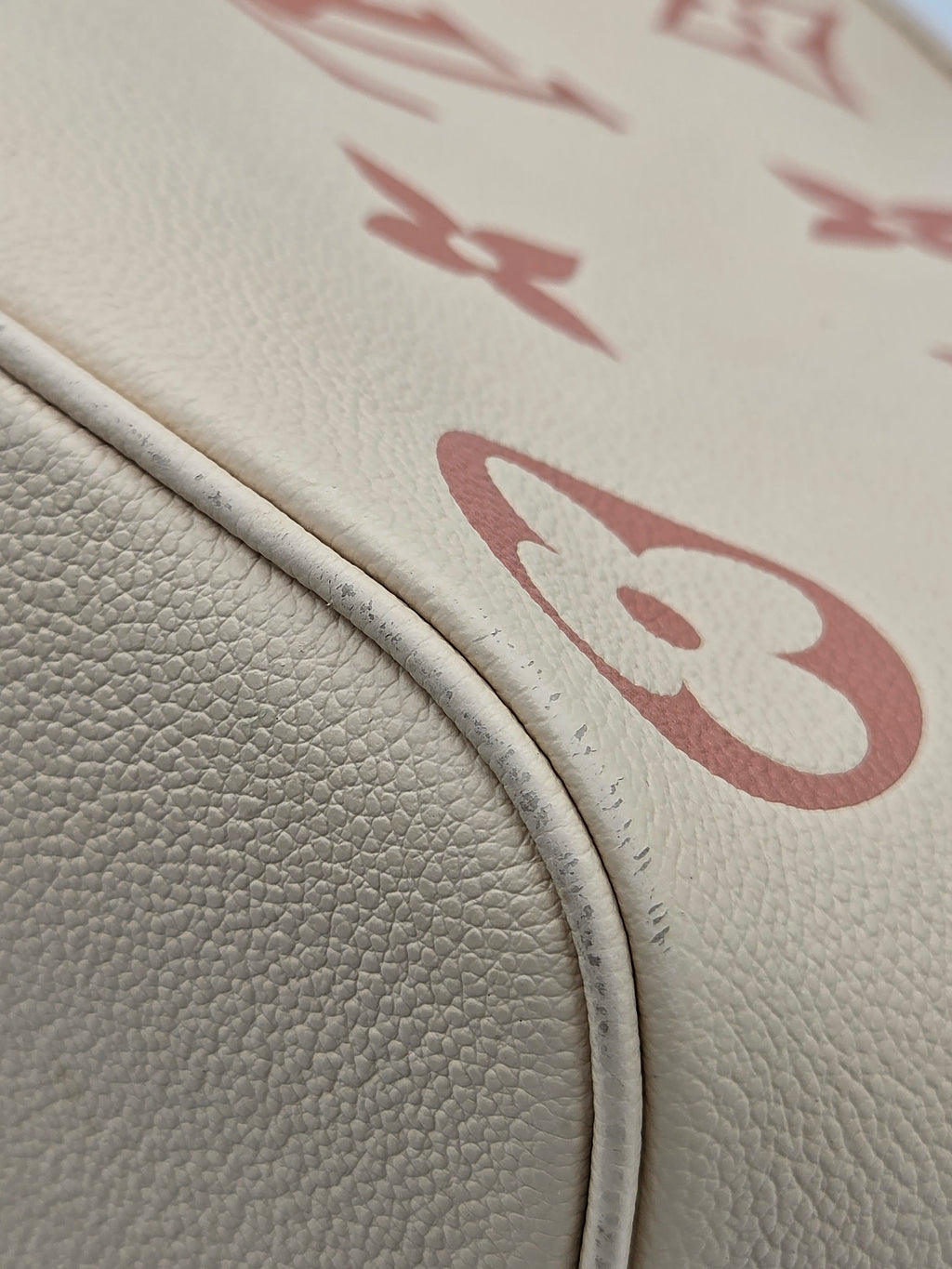 Close-up of beige leather surface with red logo pattern