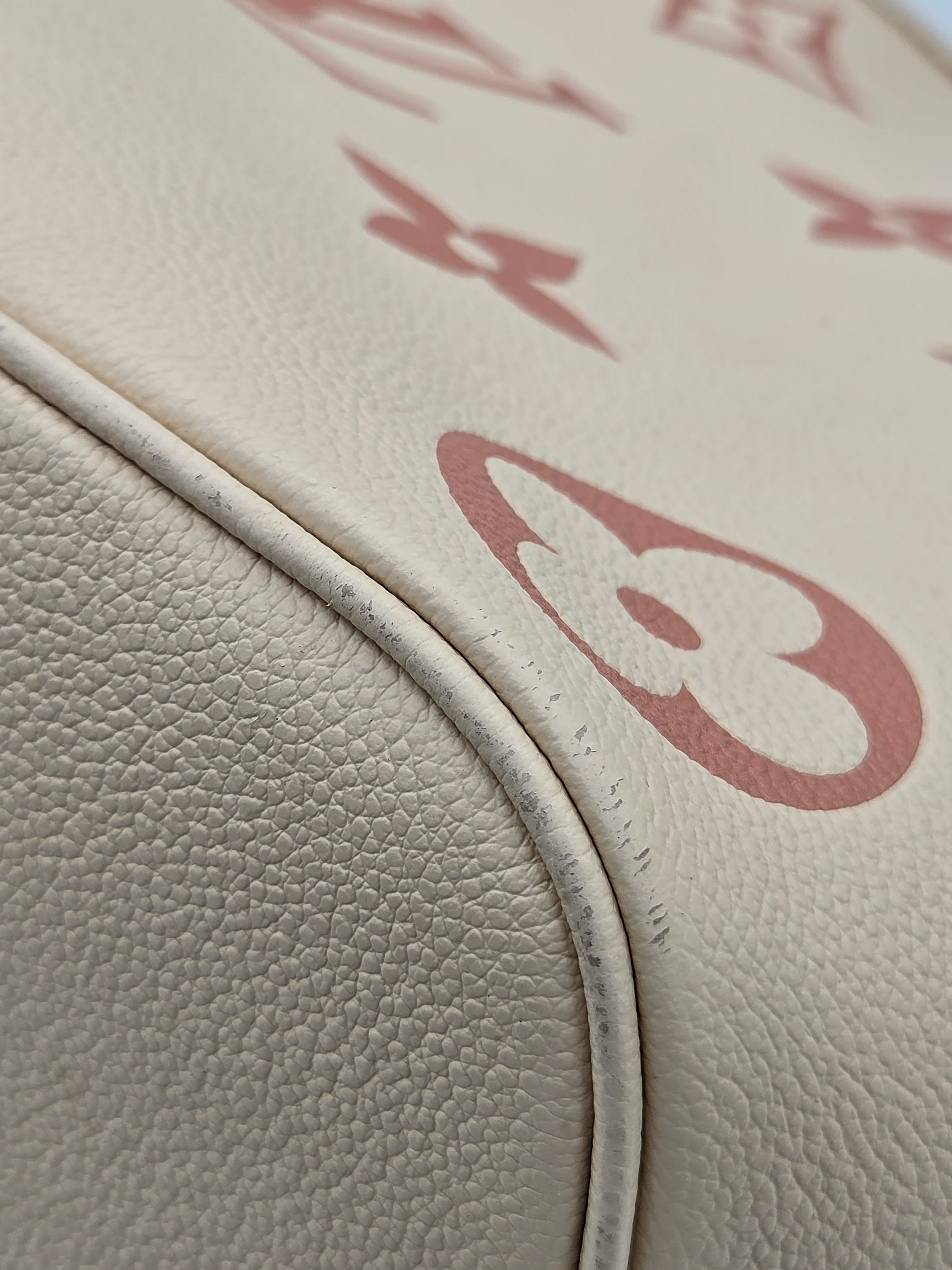 Close-up of beige leather surface with red logo pattern