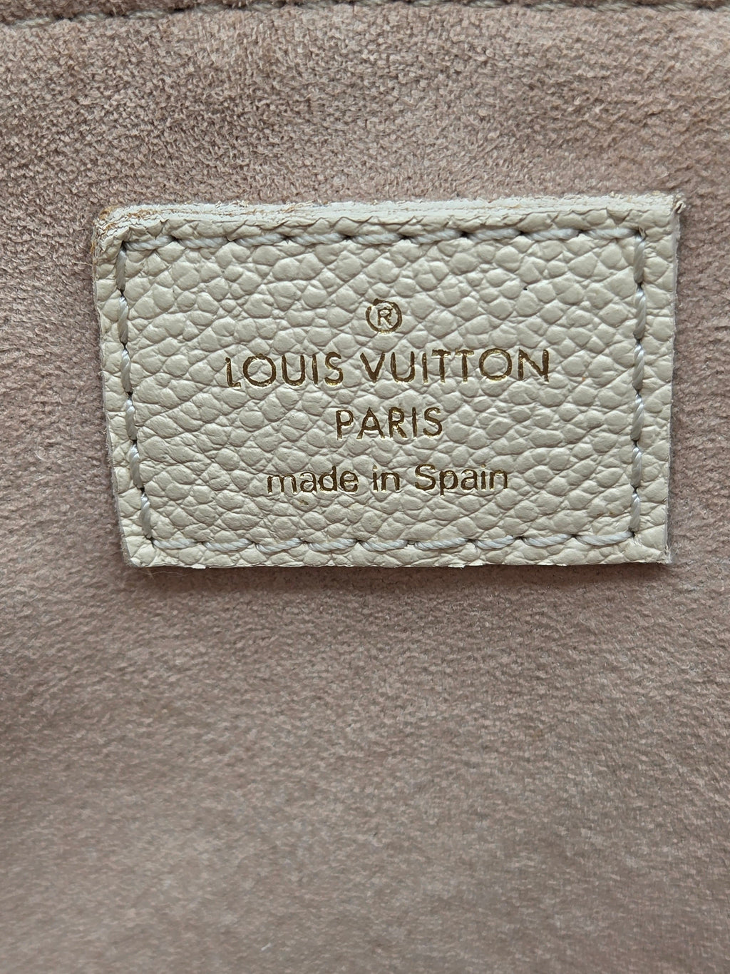 Louis Vuitton label on a textured beige background