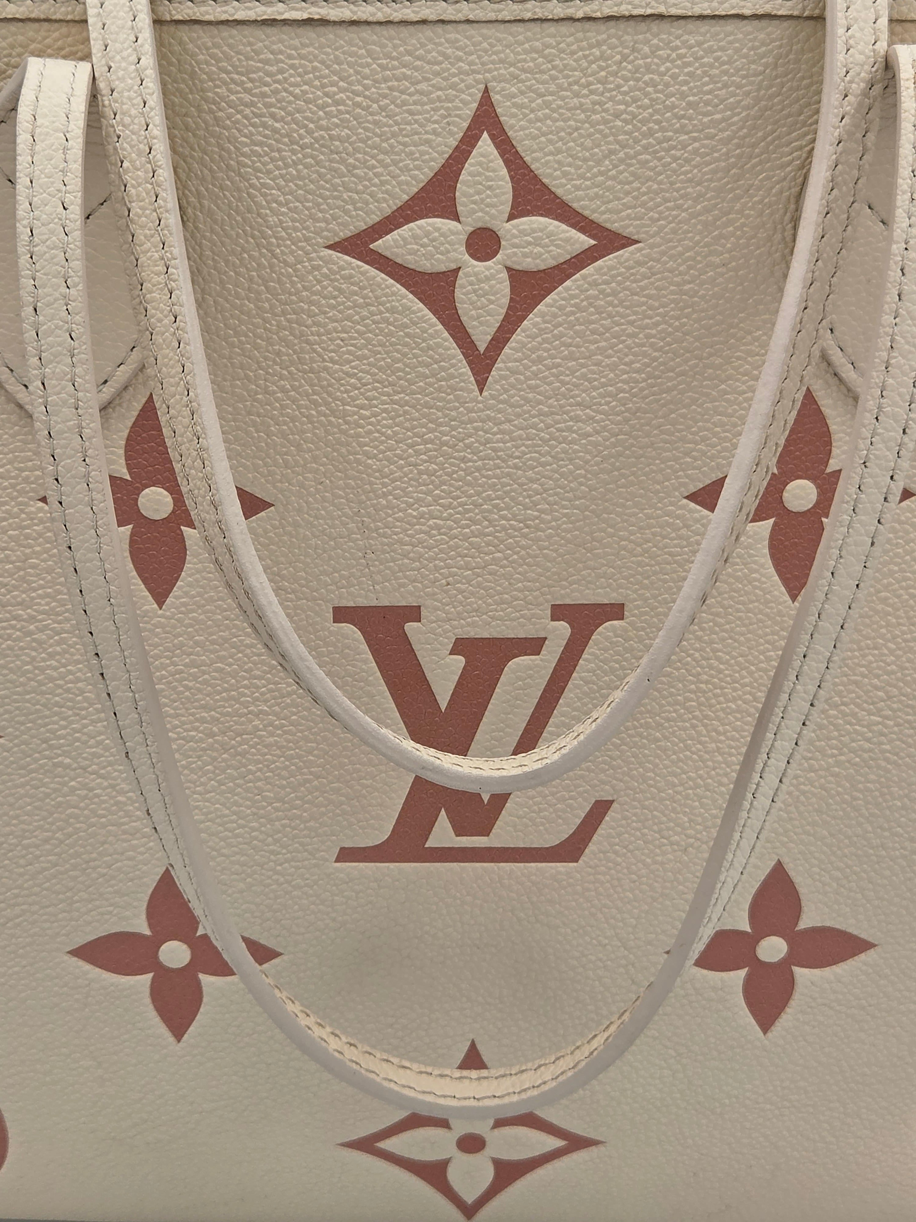Close-up of a beige leather bag with red monogram pattern