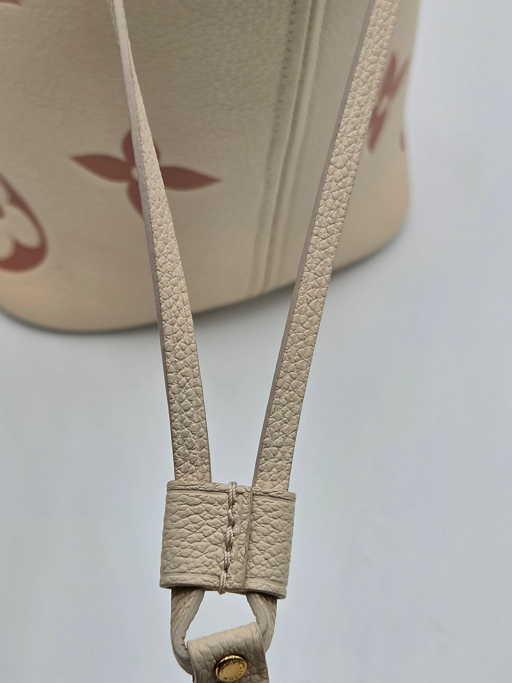 Close-up of a beige leather strap on a product with a blurred background