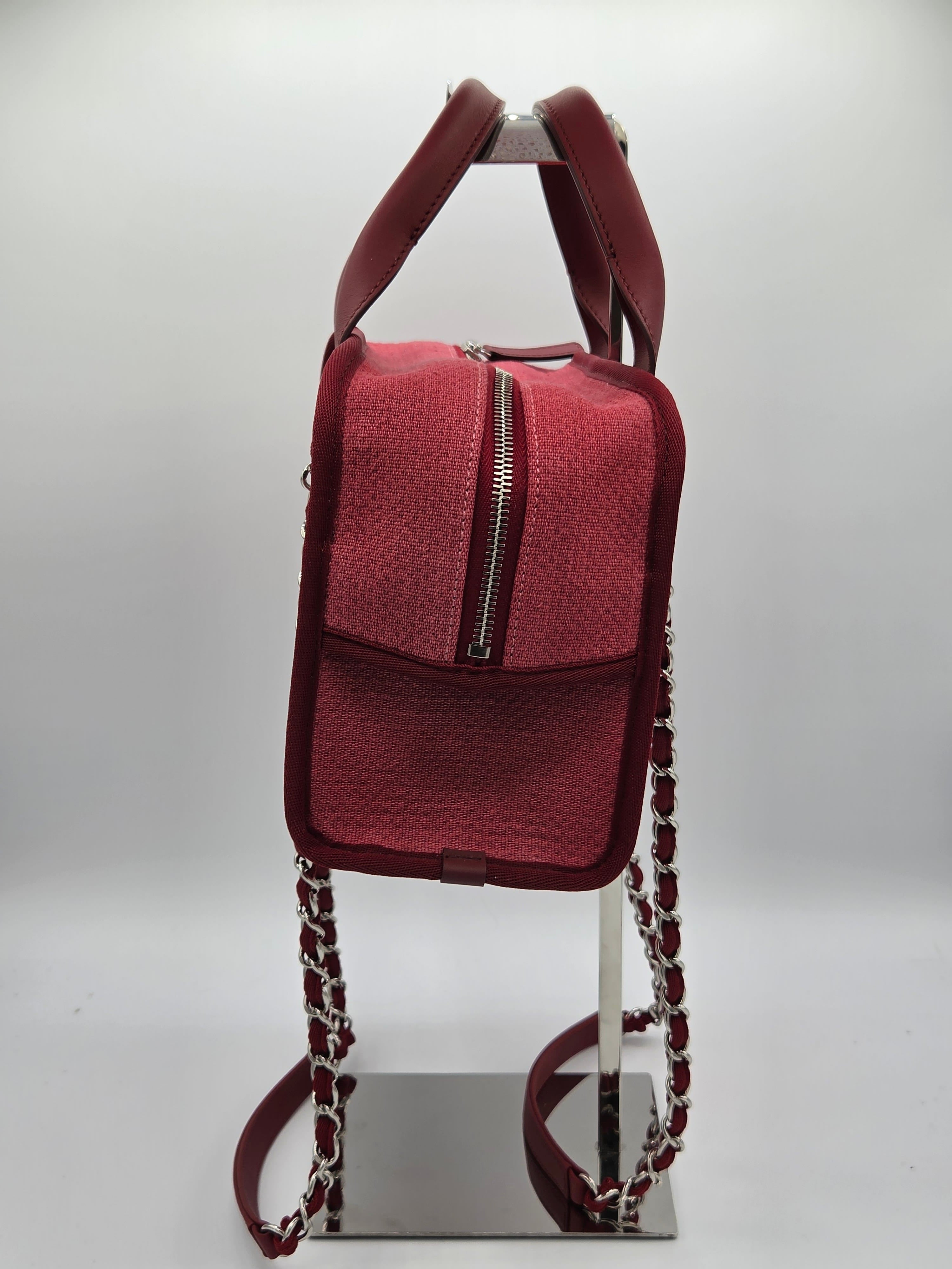 Maroon handbag with chain strap on a white background