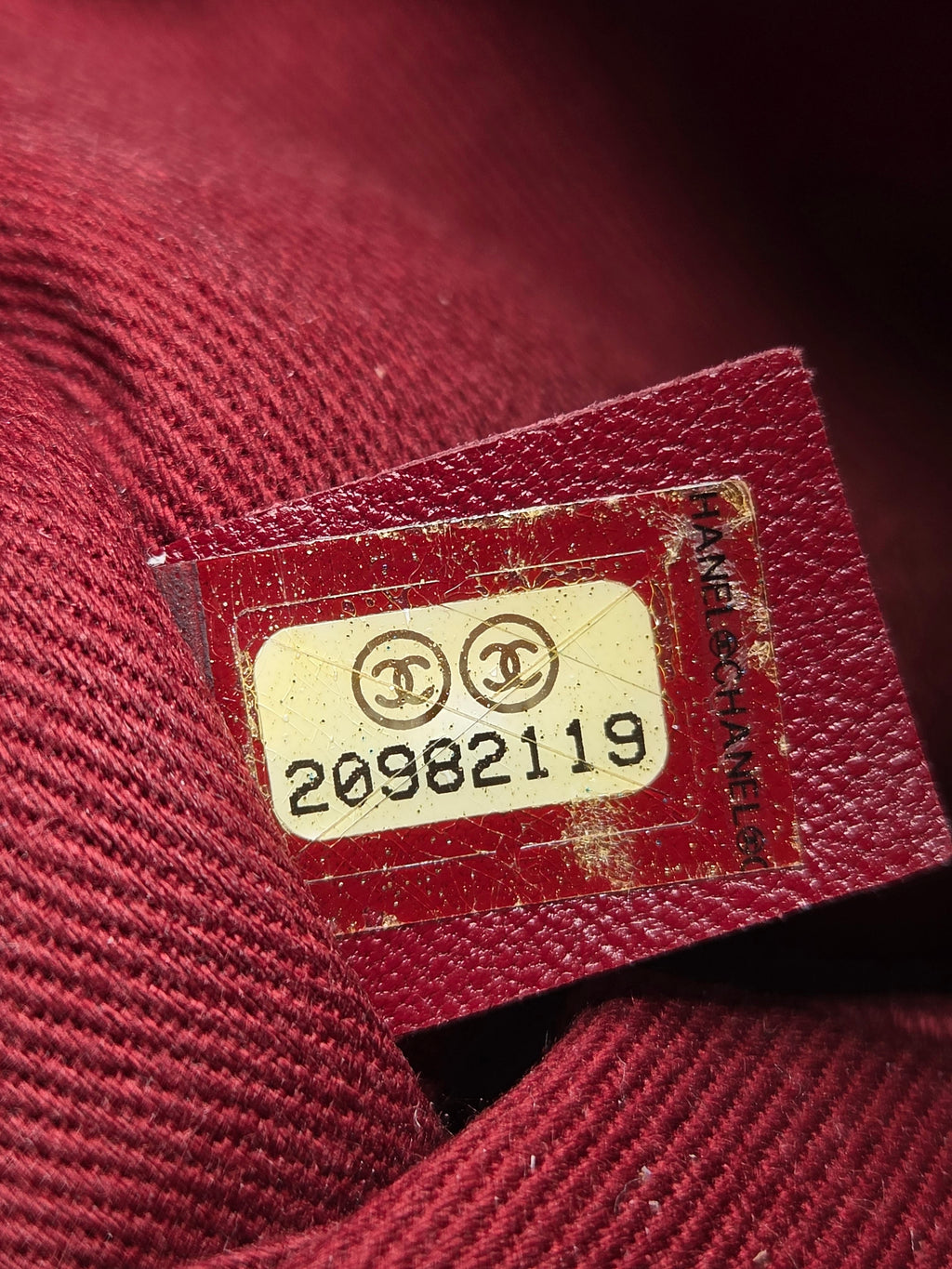 Close-up of a Chanel label on a red fabric background