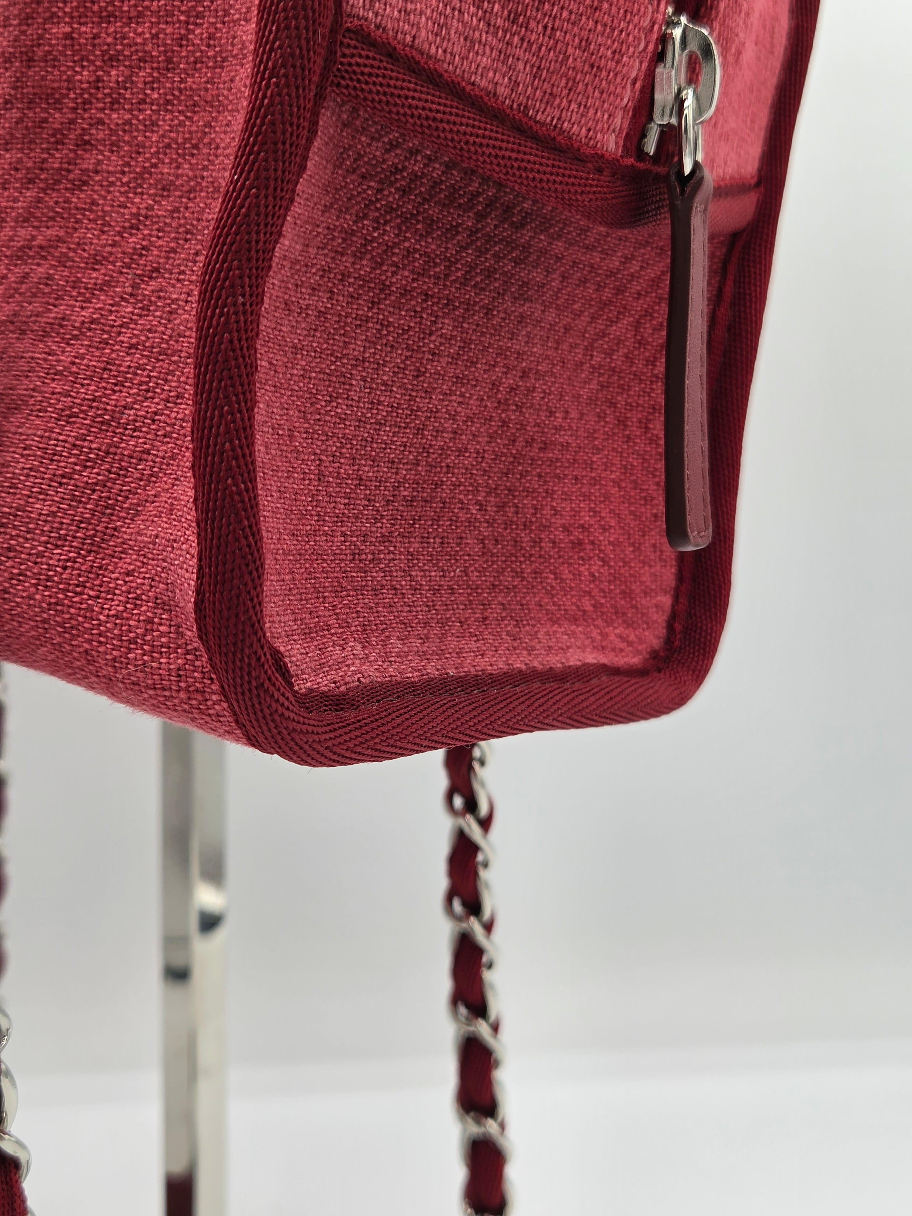 Close-up of a red handbag with a chain strap on a white background