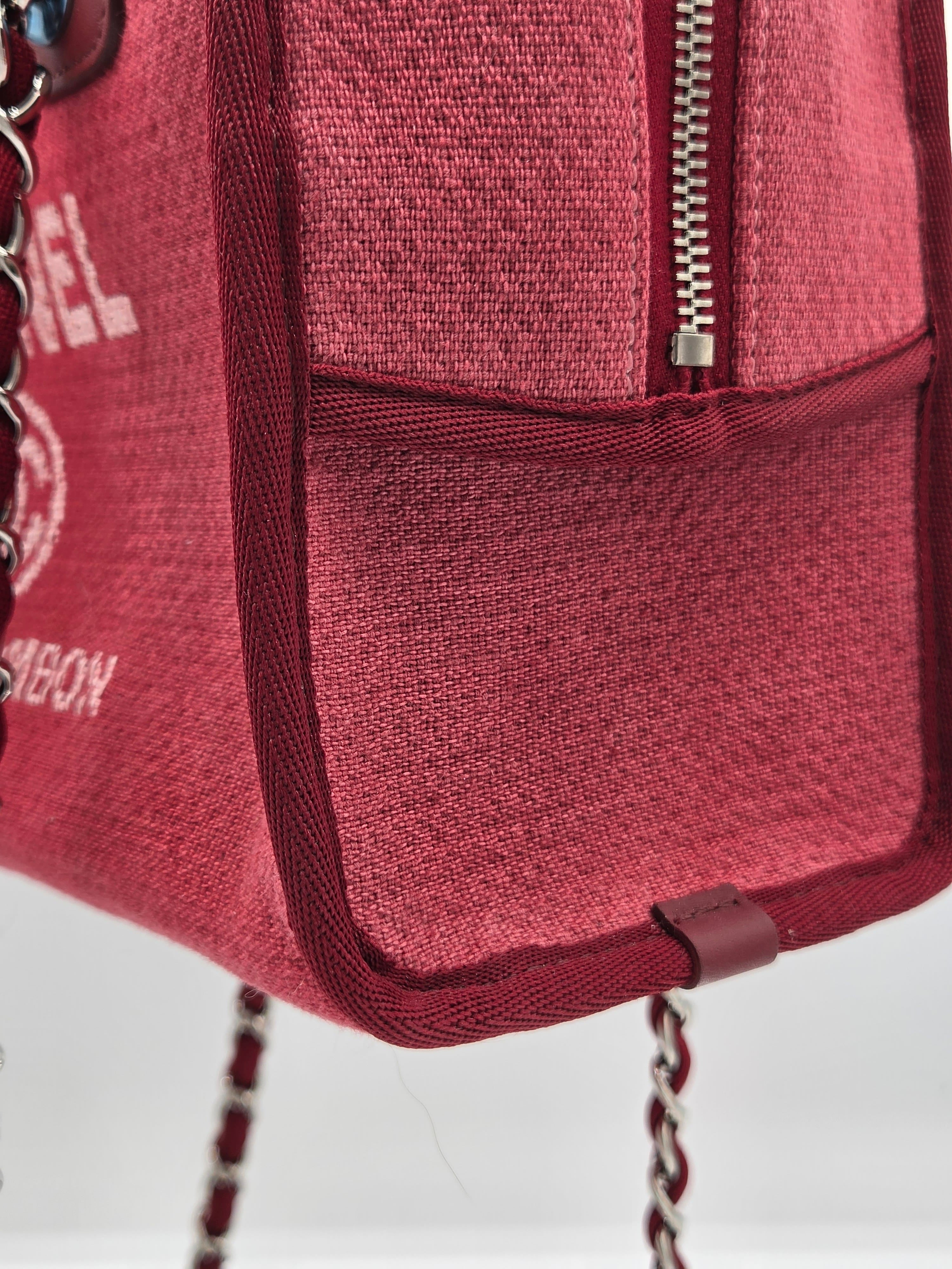 Close-up of a red textured bag with a chain detail on a white background