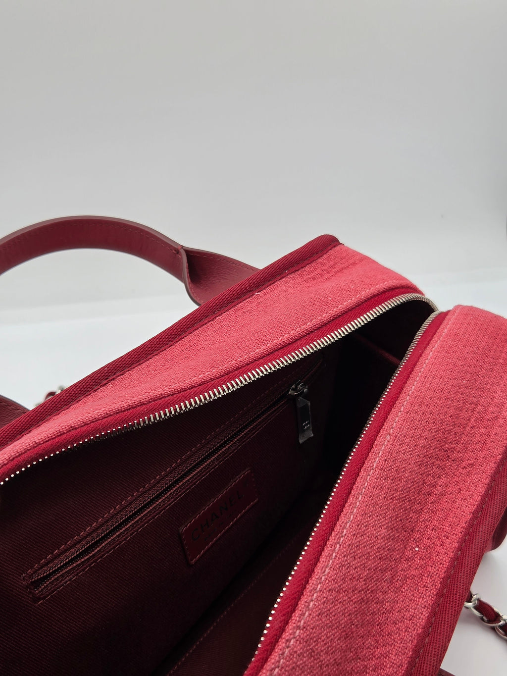 Red backpack with a zipper on a light gray background