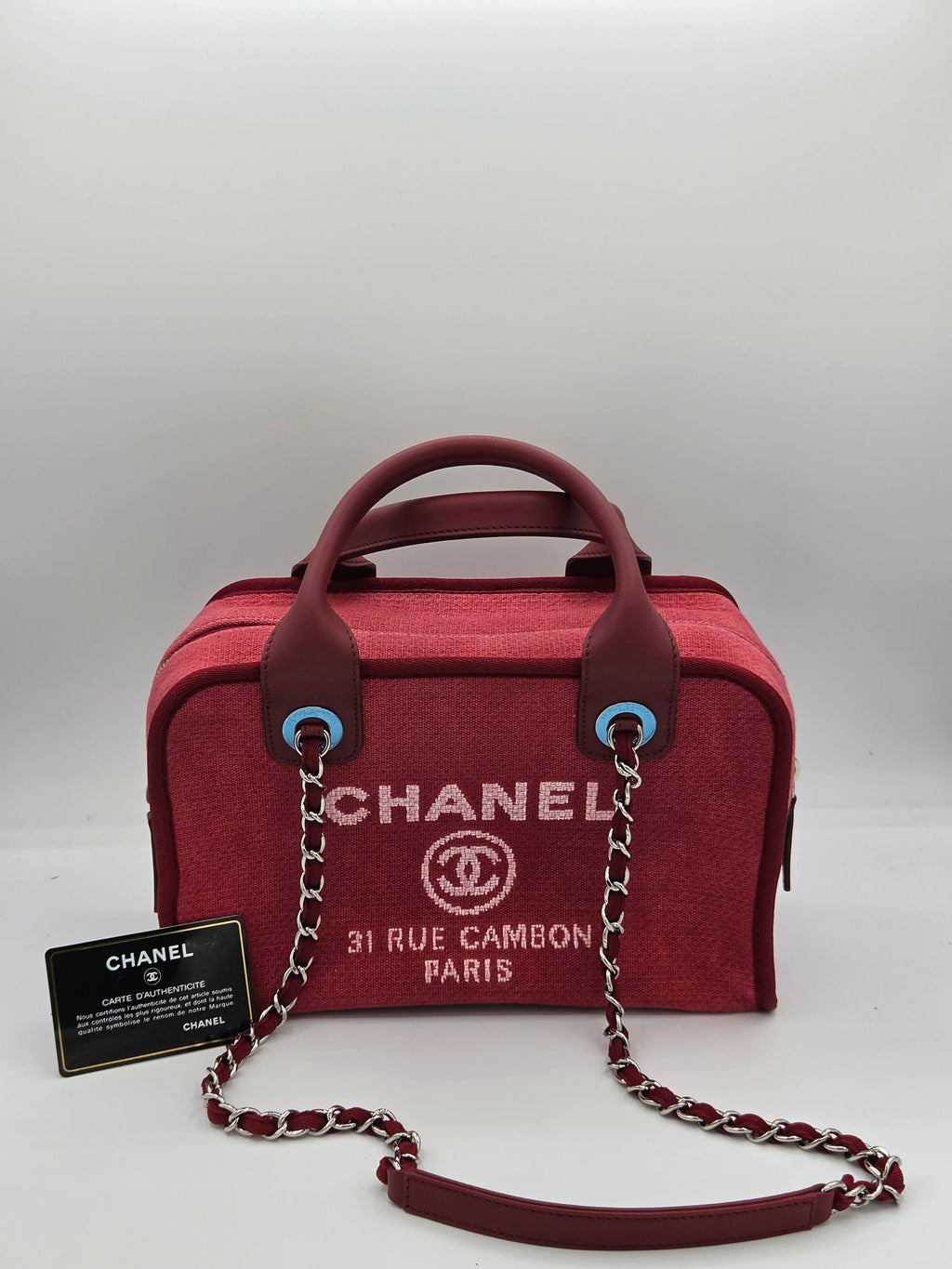 Red Chanel handbag with chain strap on a light gray background