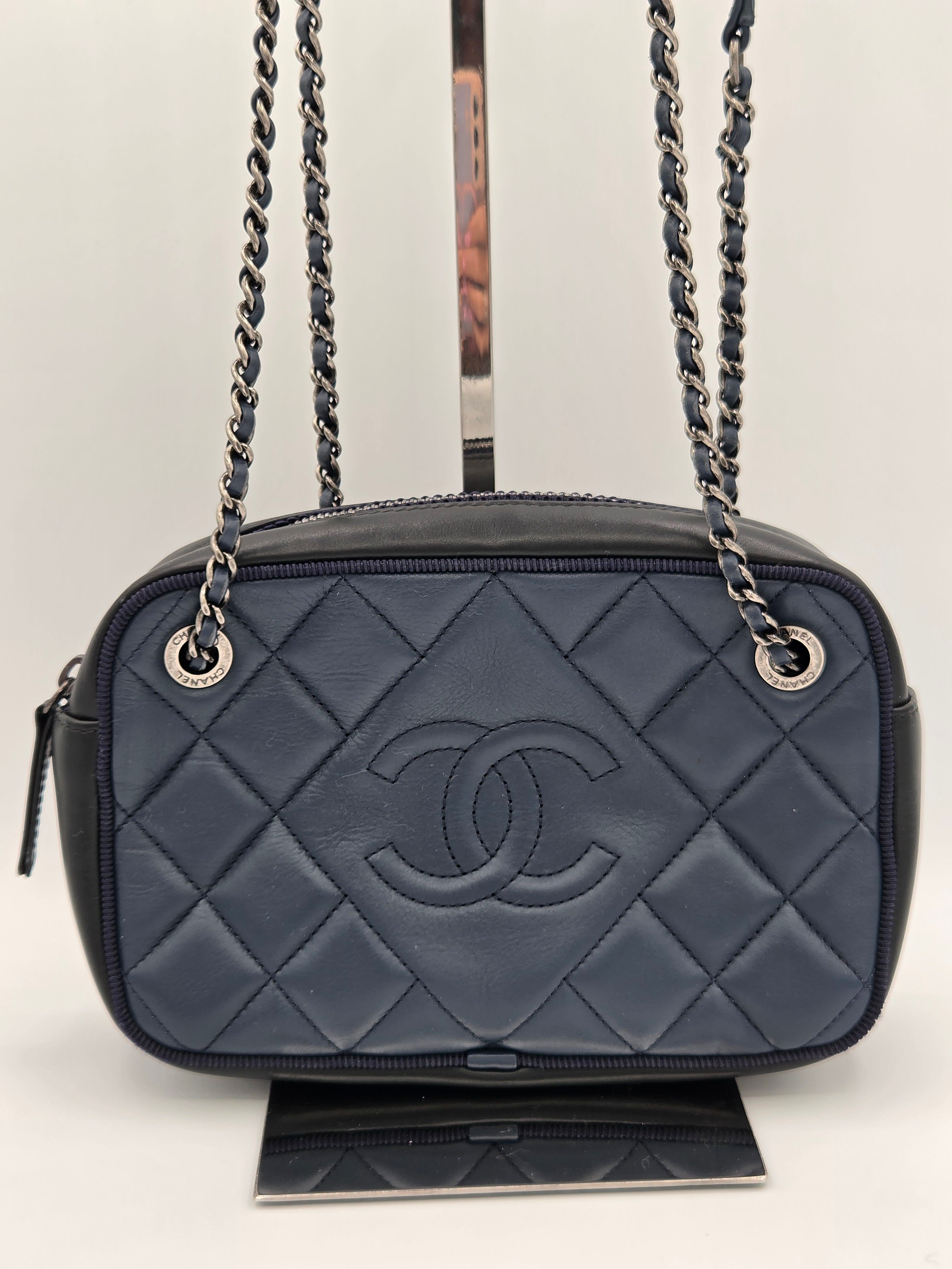 Gray quilted handbag with a chain strap on a light gray background