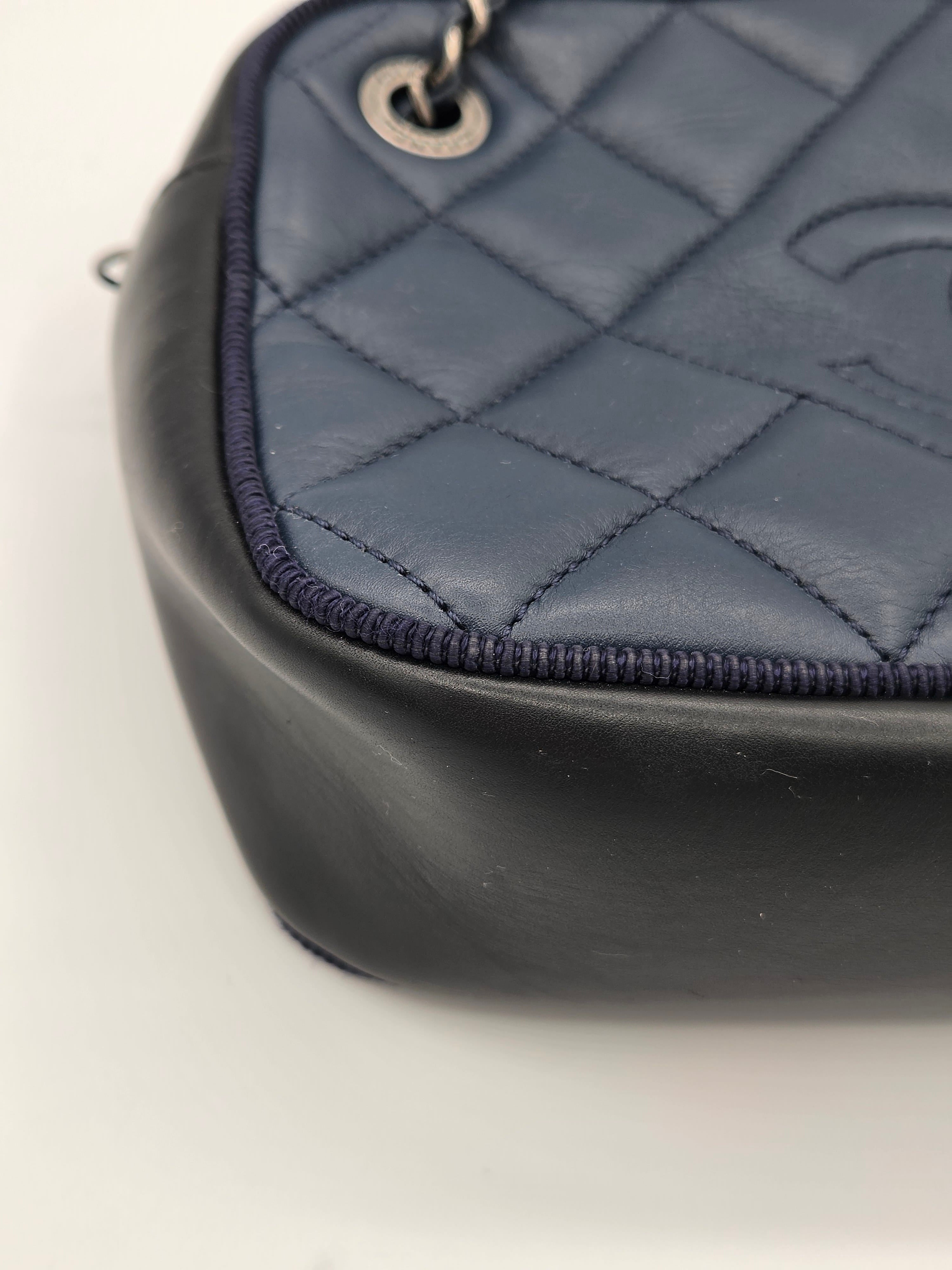 Close-up of a quilted handbag with a visible brand logo on a white background
