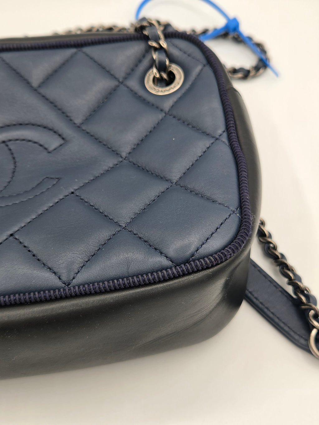Quilted black handbag with chain strap on a light background