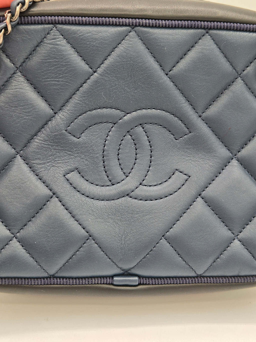 Gray quilted handbag with a brand logo on a beige background