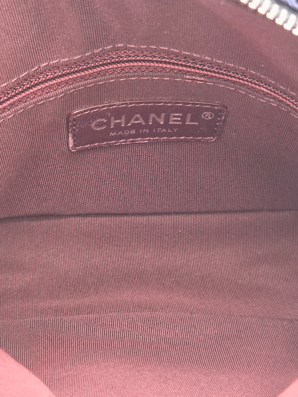 Close-up of a Chanel label on a brown fabric surface